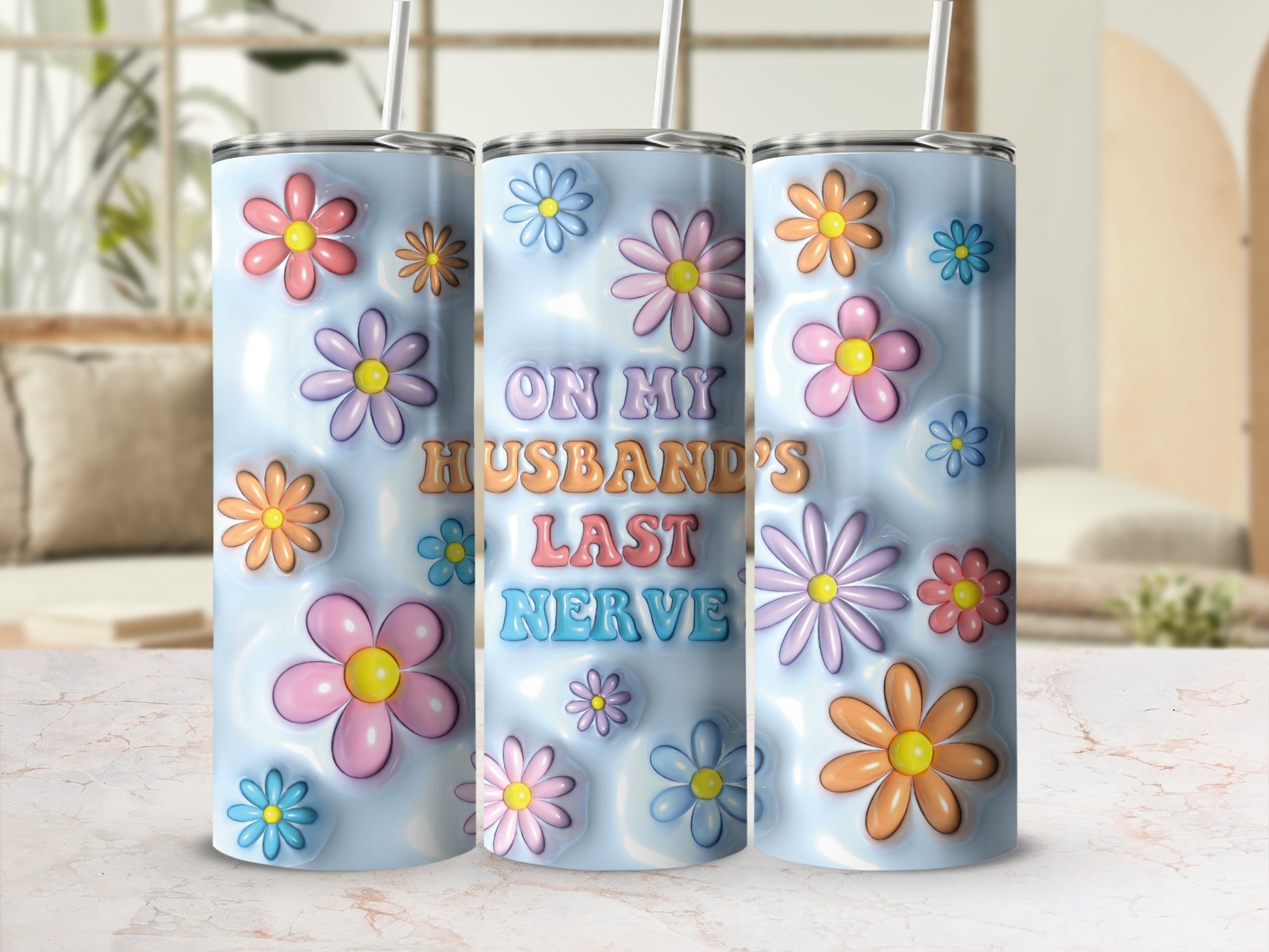 Tumbling blue tumbler with pastel flowers and "ON MY HUSBAND'S LAST NERVE" text.