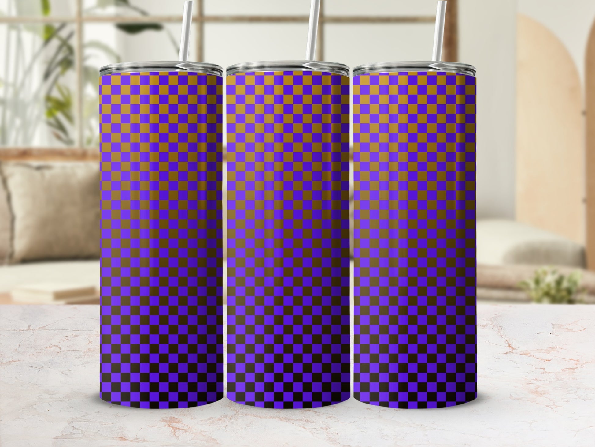 Purple and orange checkered tumbler with straw, on a marbled surface.