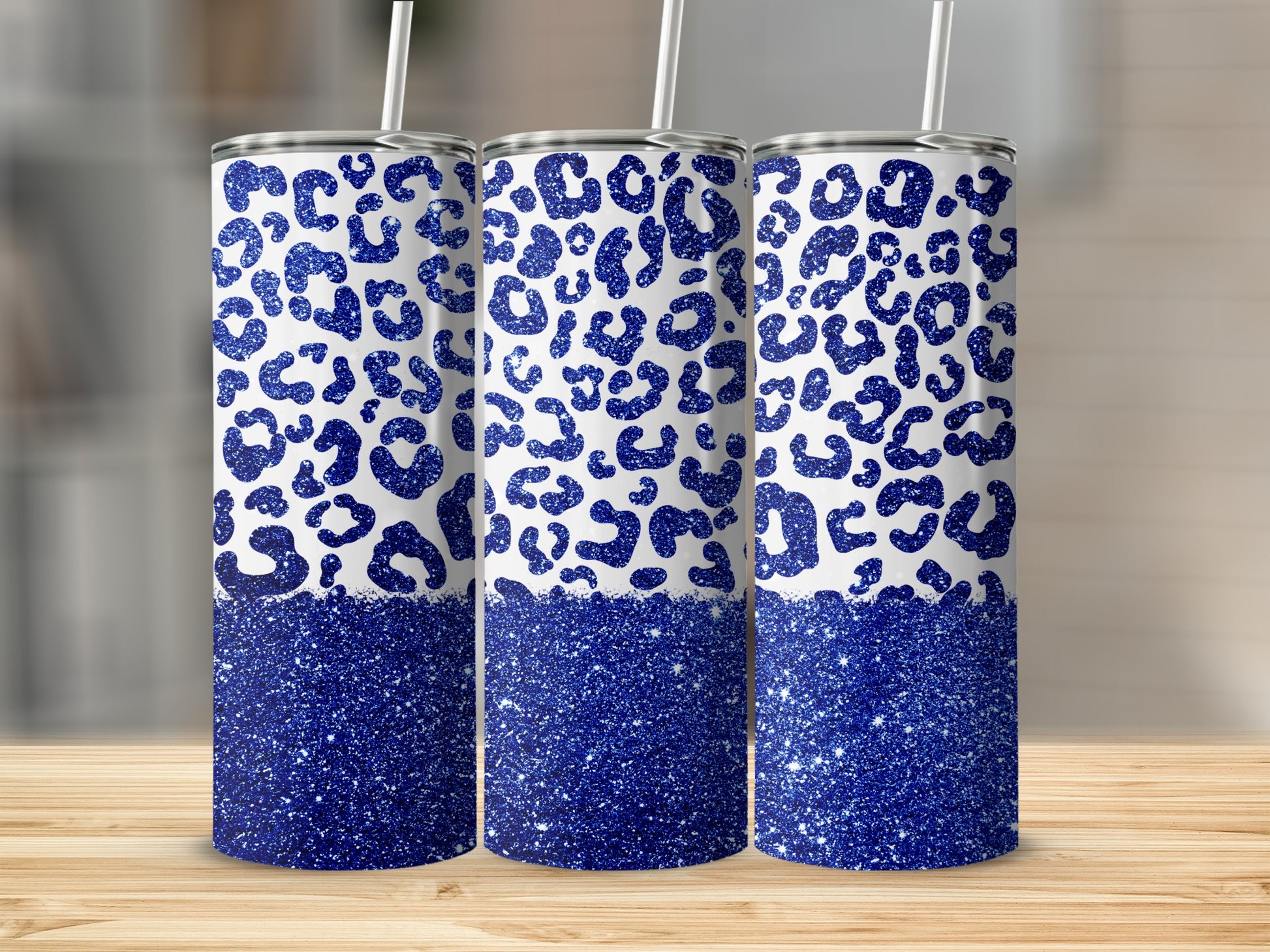 Three tumblers with blue leopard print and glitter bottoms.