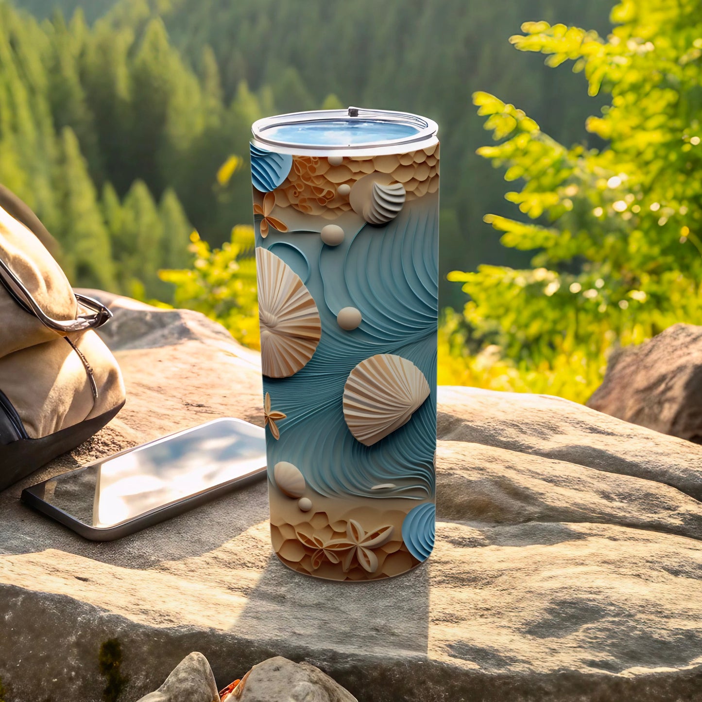 Seashell and wave pattern tumbler on rock with backpack and phone.