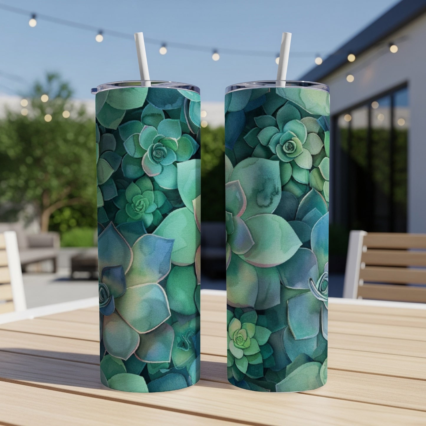 Two tumblers with a watercolor succulent pattern on a wooden table outdoors.