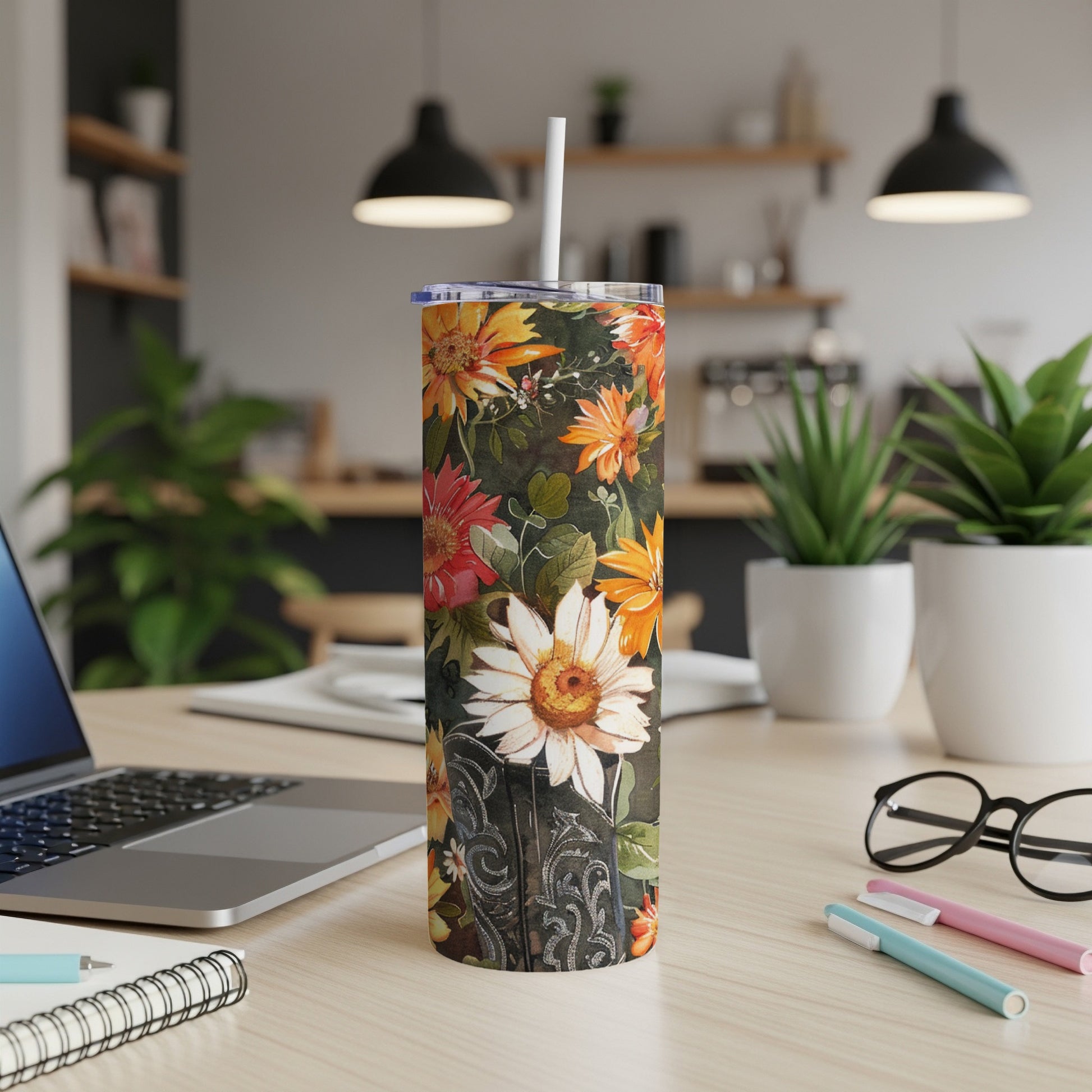 Floral print skinny tumbler with white lid and straw on a desk.