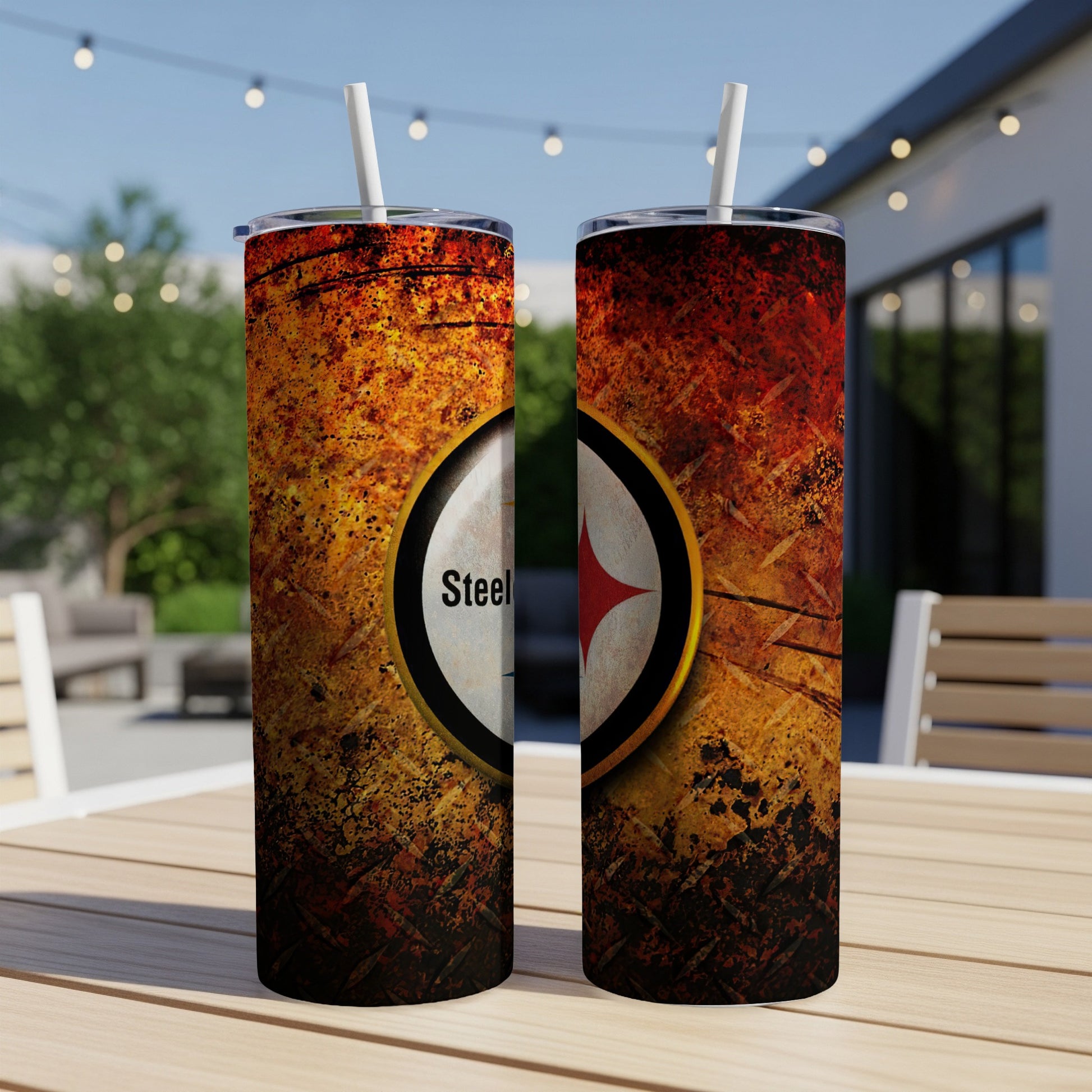 Two Pittsburgh Steelers tumblers with straws on a wooden table.