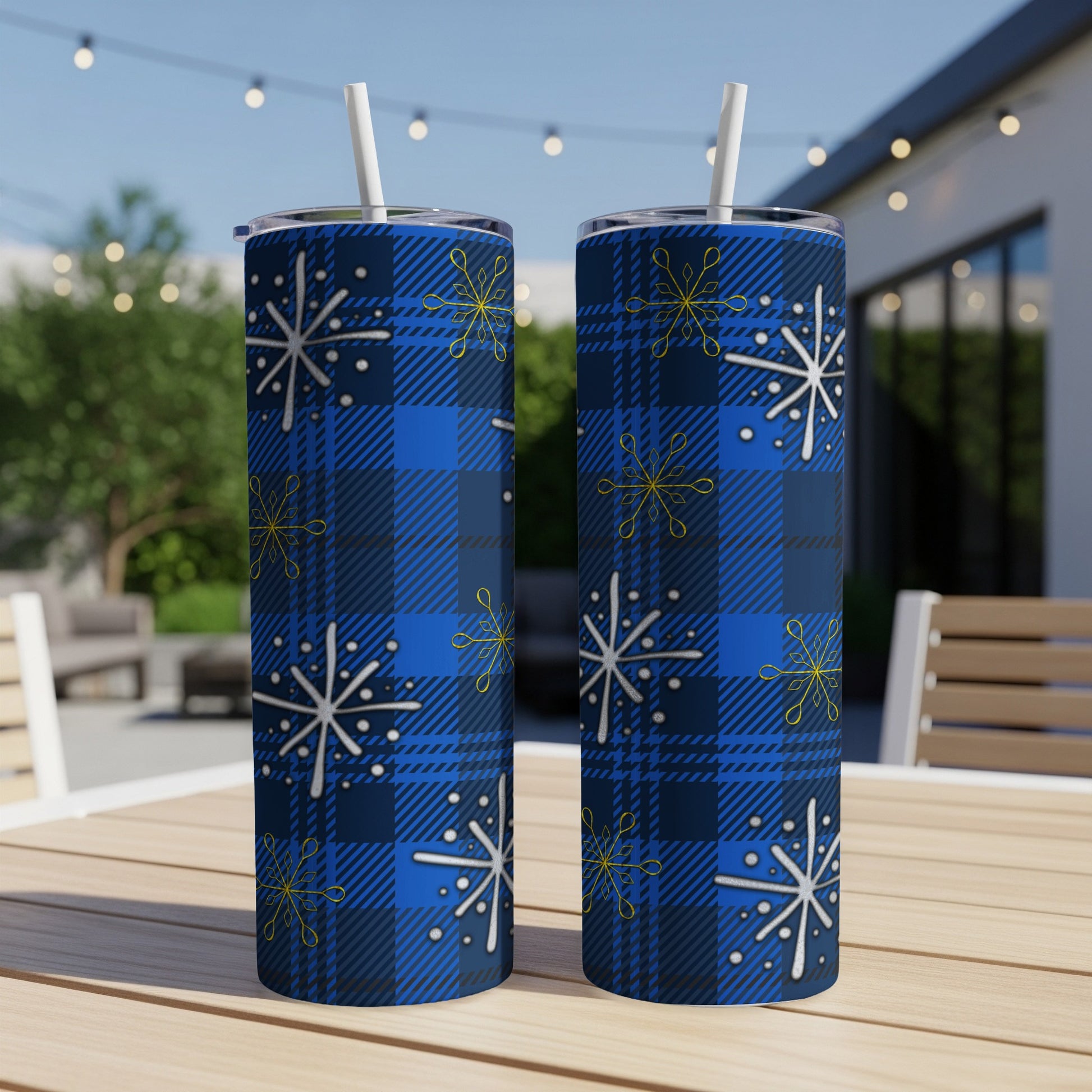 Two blue plaid tumblers with white and yellow snowflake designs.