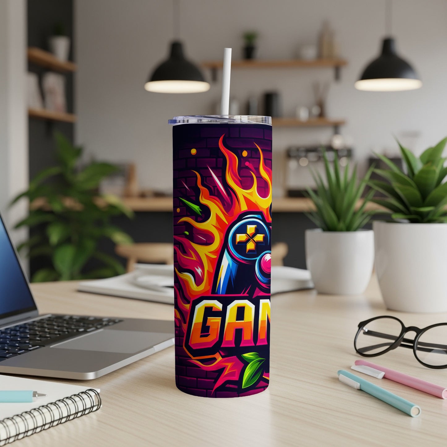 Gaming controller with flames and "GAMER" text on a purple graffiti tumbler.
