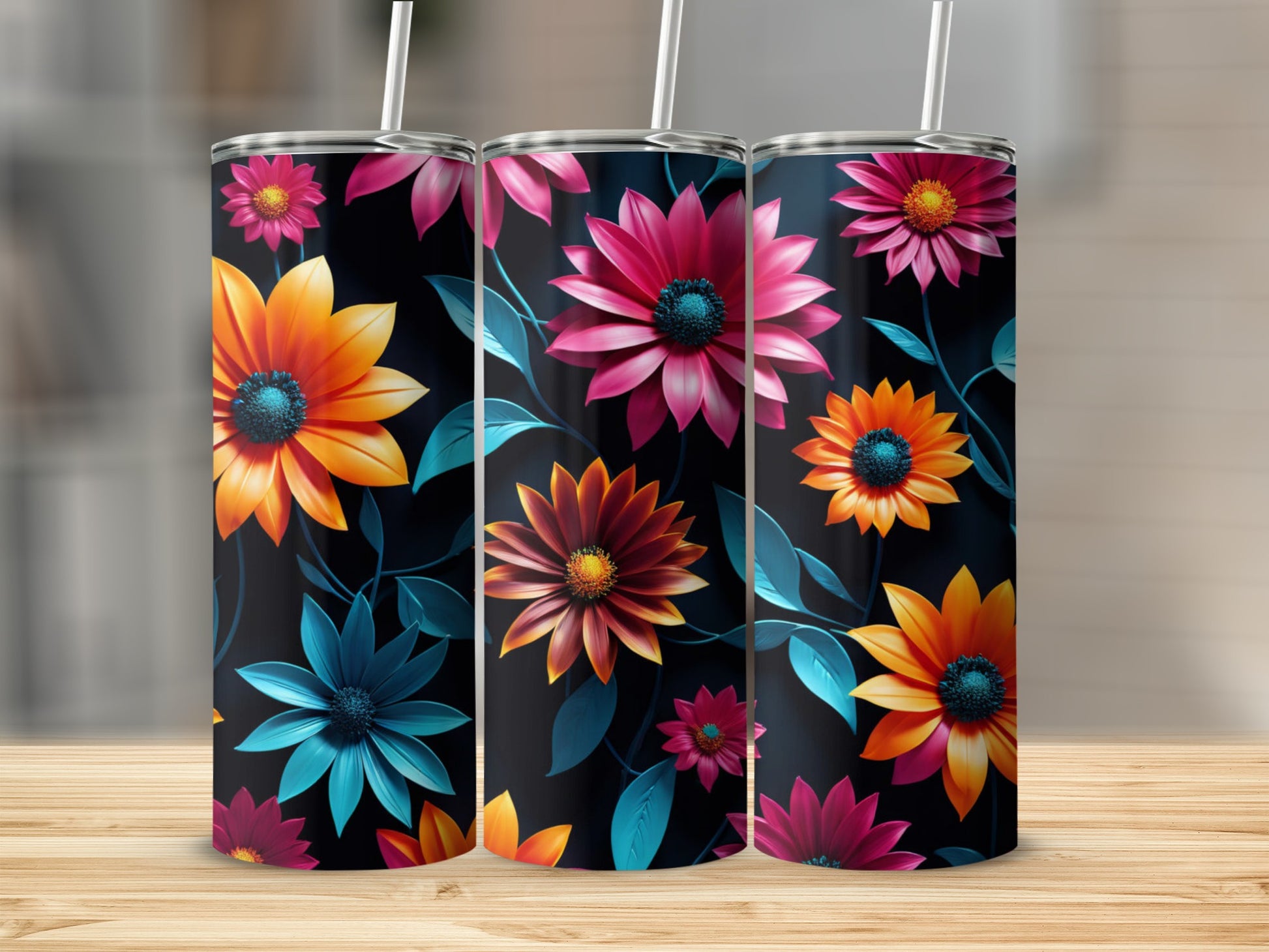 Three tumblers with vibrant floral patterns on a wooden surface.
