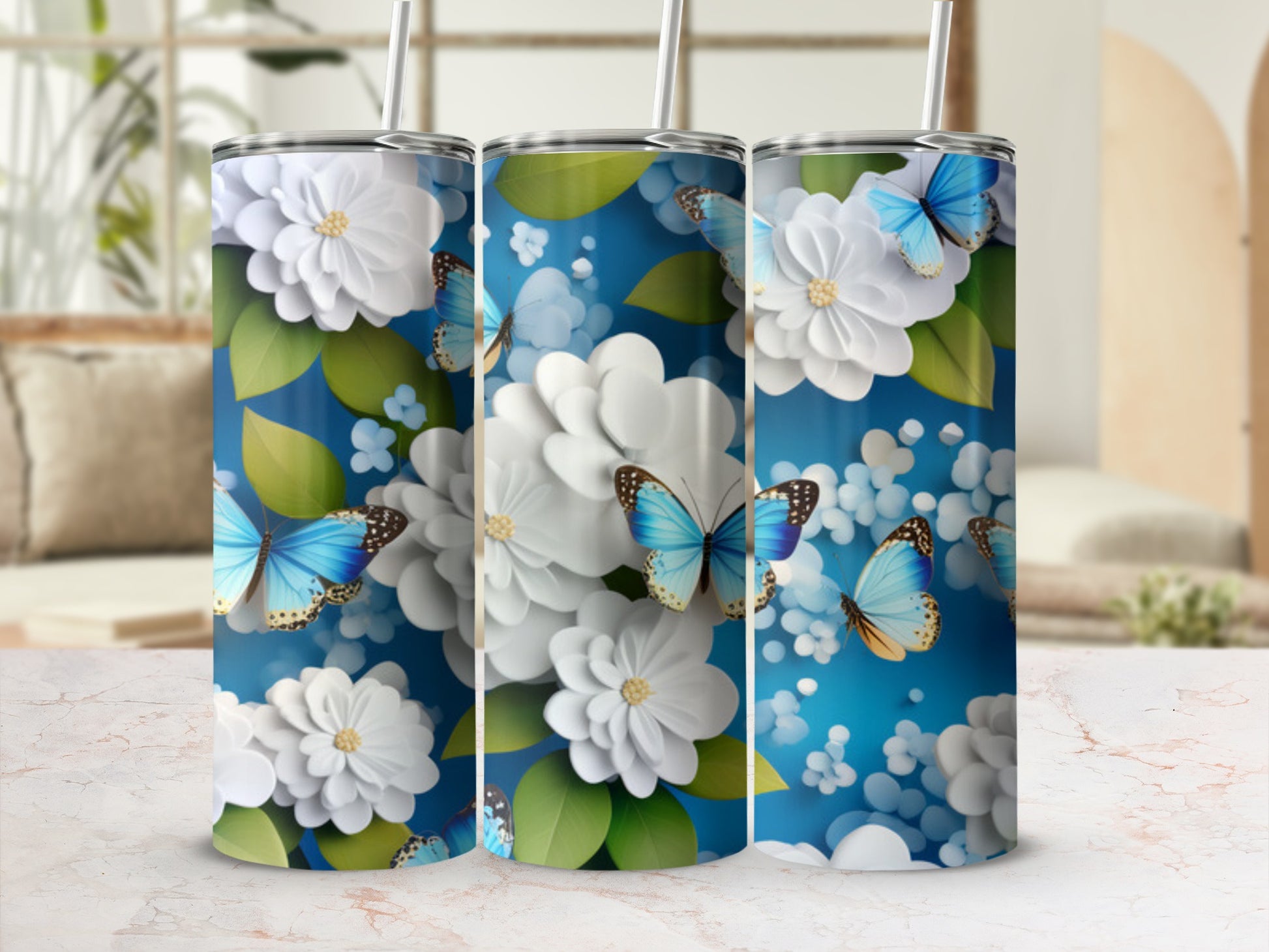 Three tumblers with blue butterflies and white flowers on a blue background.