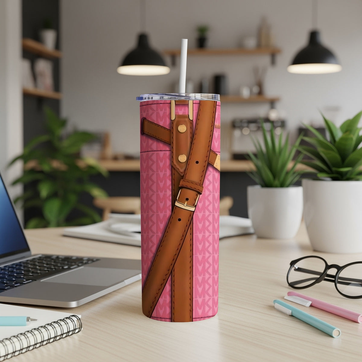 Pink tumbler with all-over logo pattern and brown strap details.