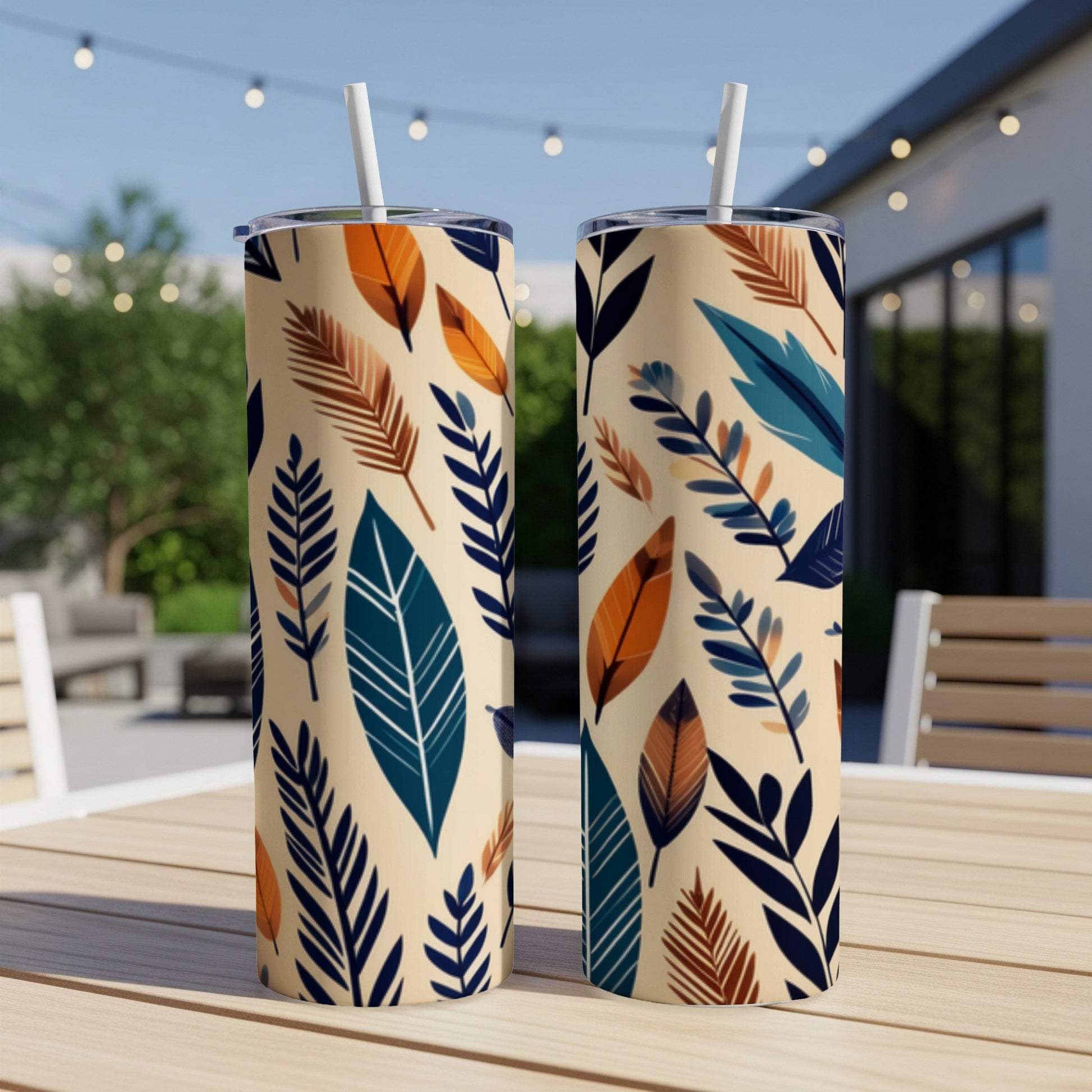 Two tall tumblers with a cream background and a repeating pattern of stylized leaves in blue, orange, and brown.