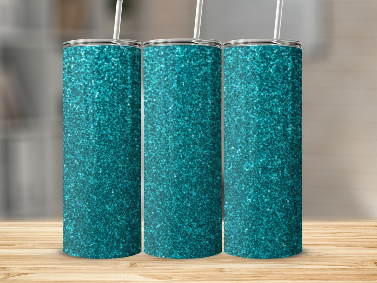 Three teal glitter tumblers with straws on a wooden surface.