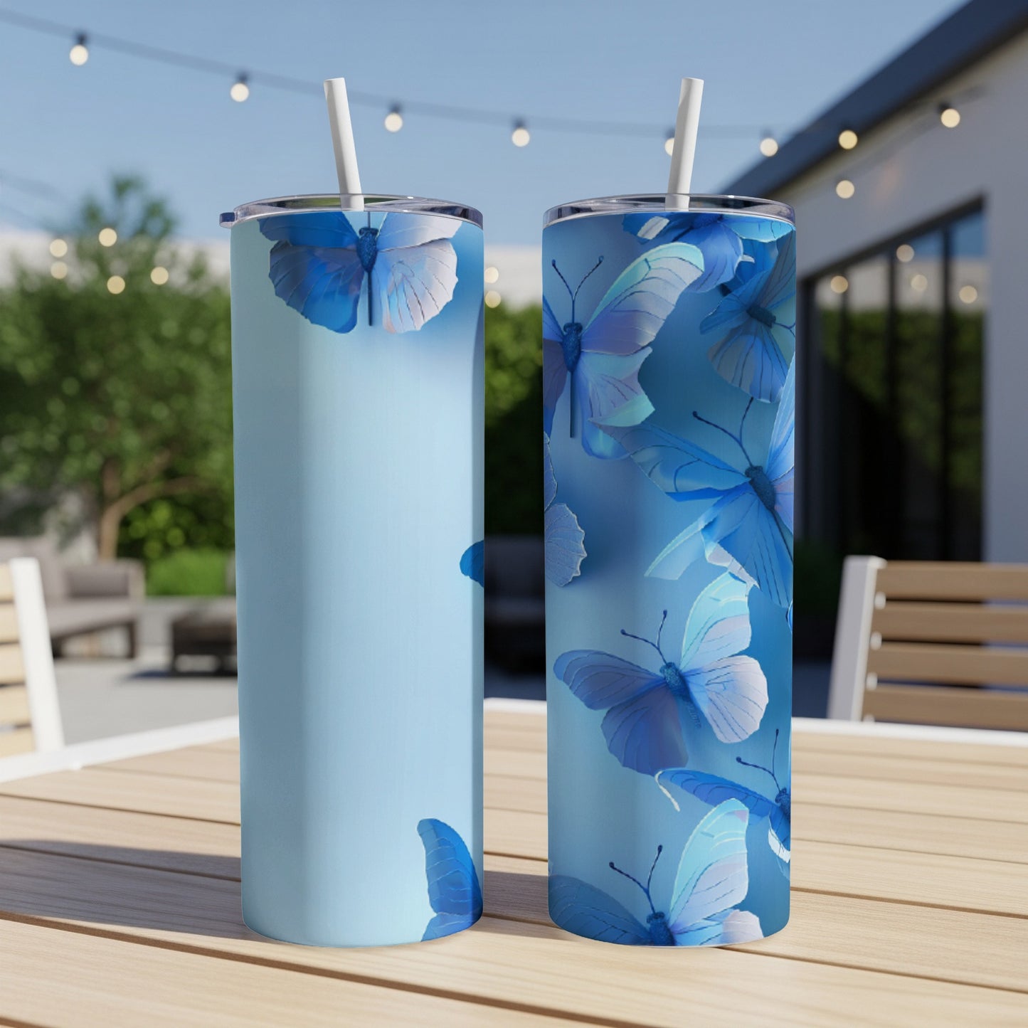 Two light blue tumblers with vibrant blue butterflies and straws.
