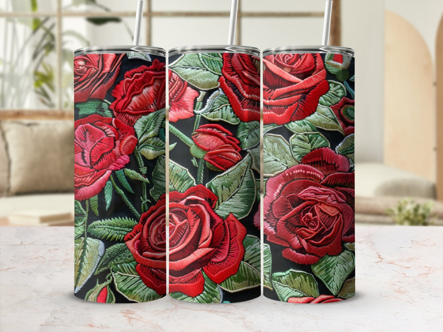Three red embroidered roses on a dark background, on tall tumblers.