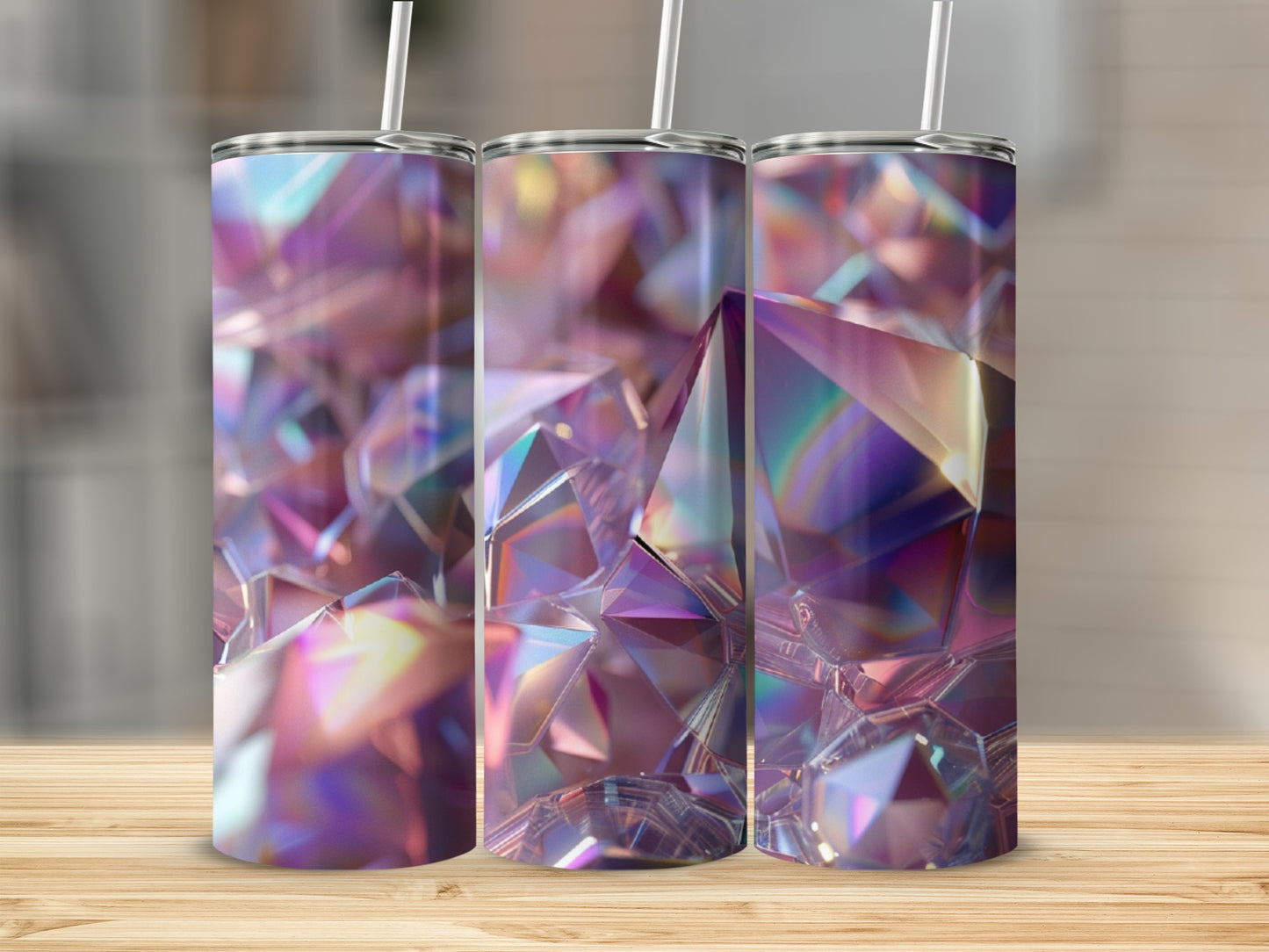 Three tumblers with iridescent, faceted gemstone designs on a wooden surface.