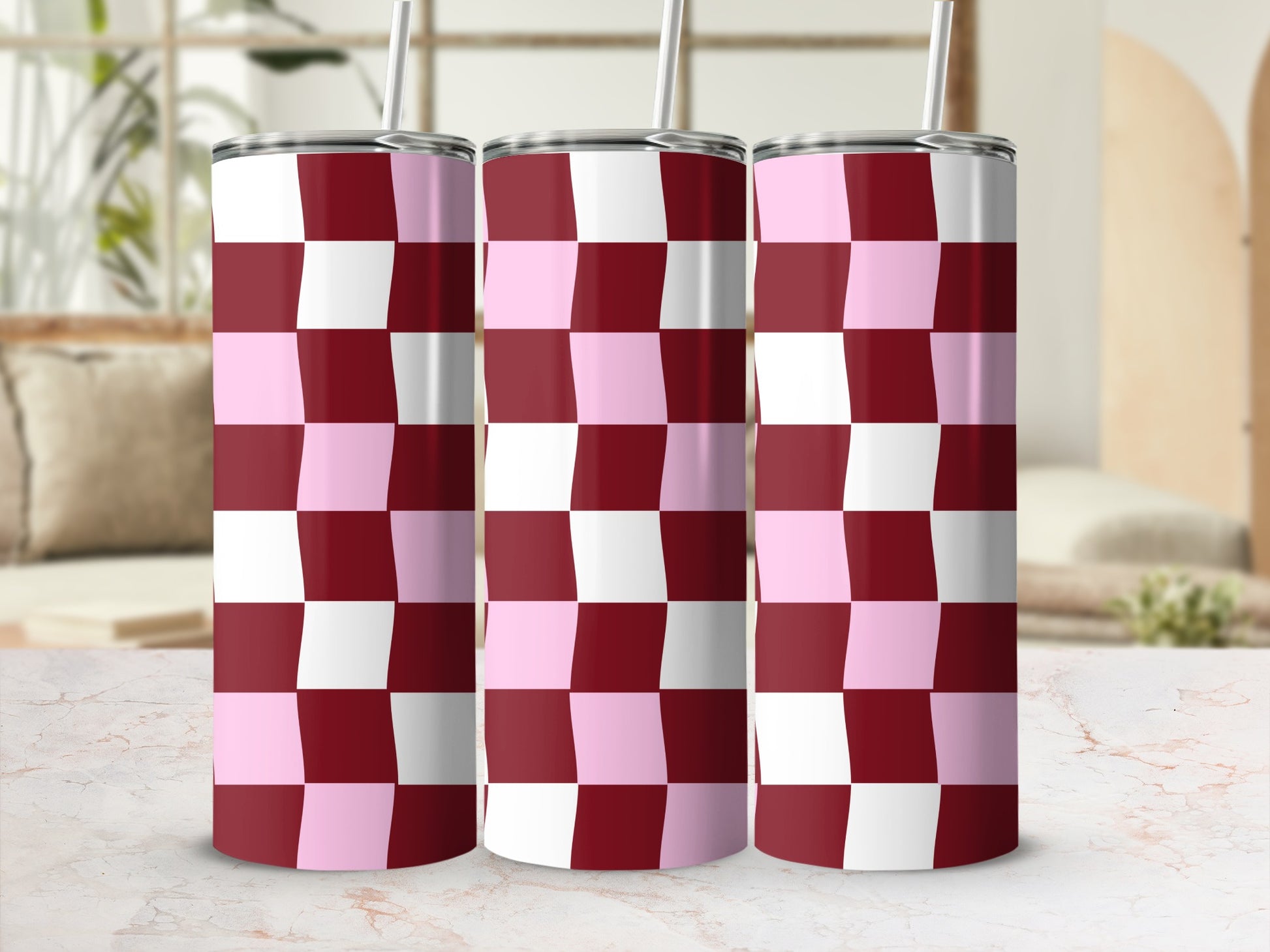 Three stainless steel tumblers with a pink and maroon checkered pattern.