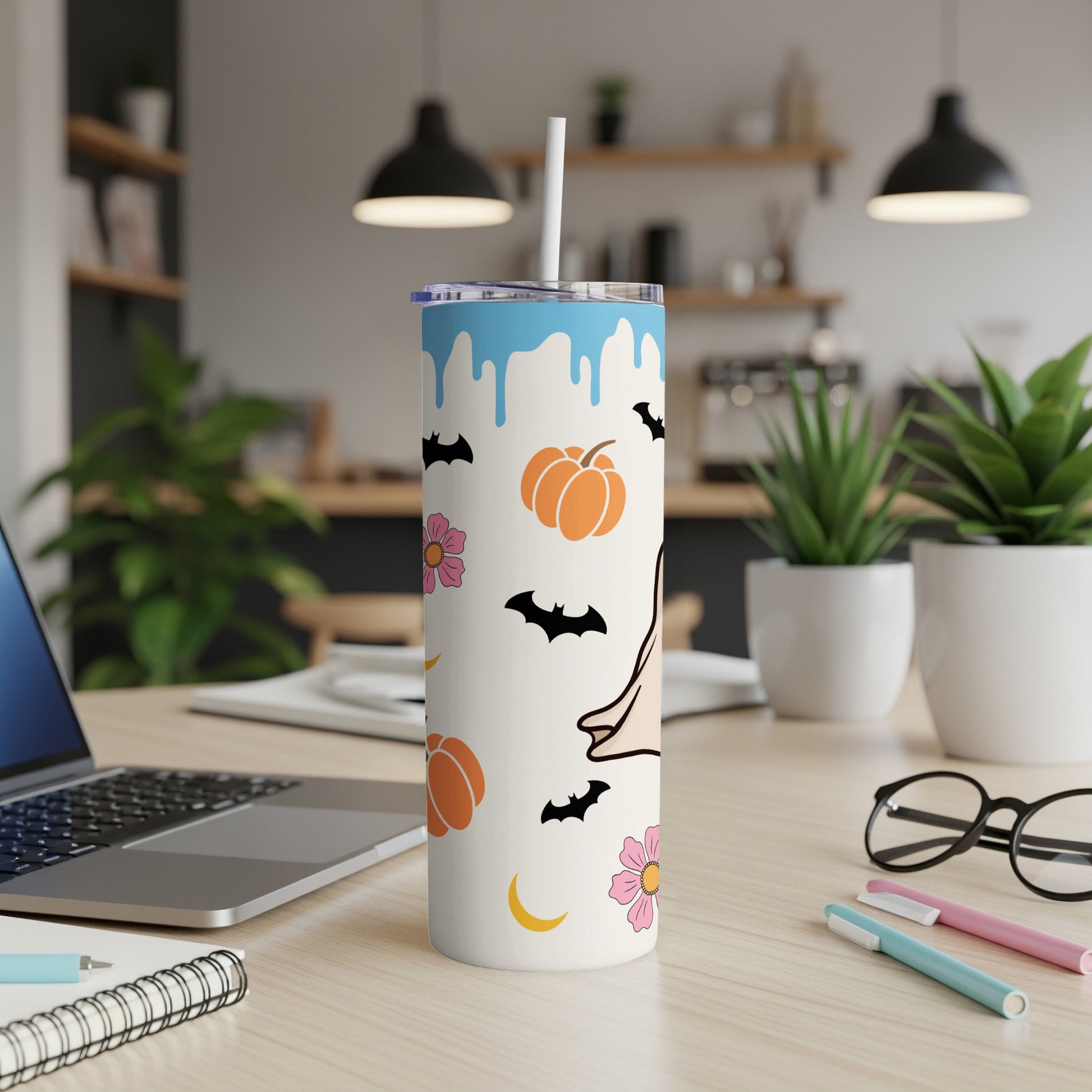 White tumbler with blue drips and Halloween icons: pumpkins, bats, flowers, moon.