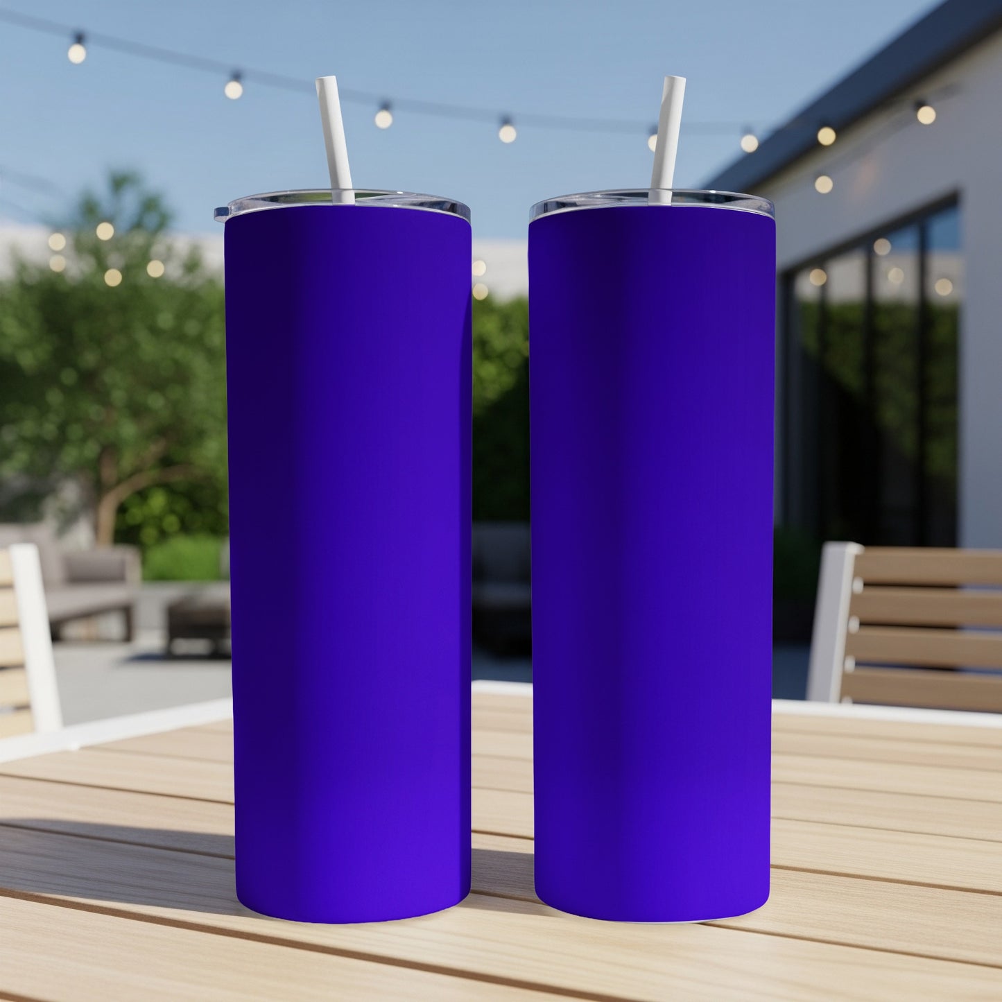 Two solid purple tumblers with white straws on a wooden table.