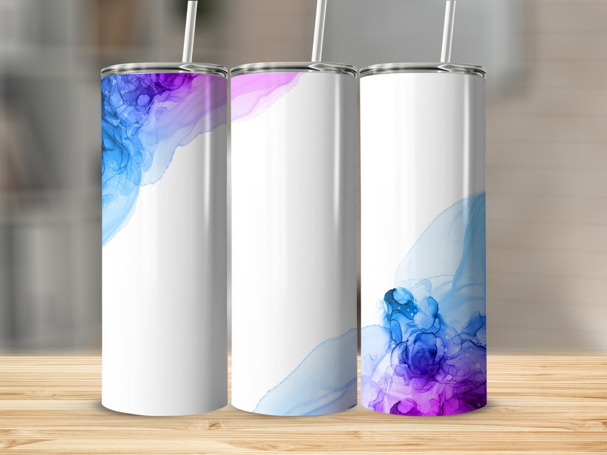 Three white tumblers with blue and purple watercolor designs.