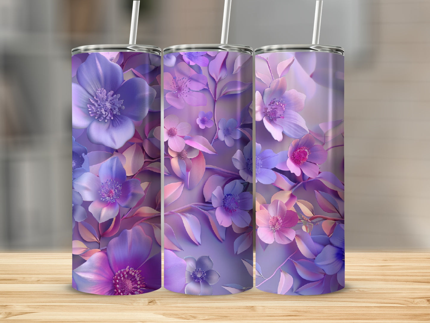 Three purple floral tumblers with straws on a wooden surface.