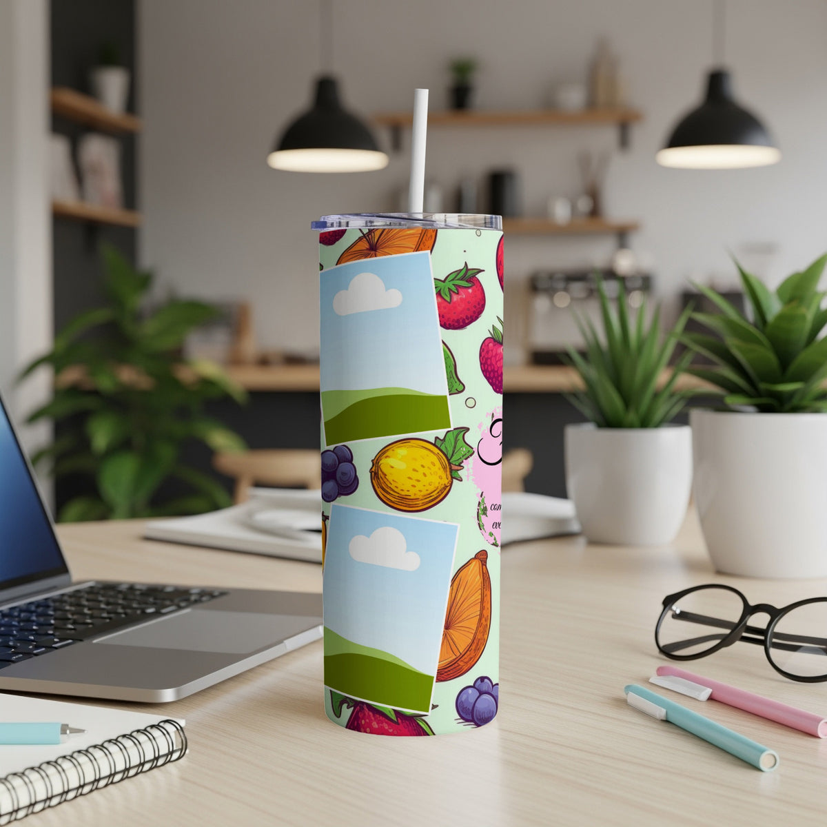 Tall tumbler with fruit pattern and photo frames on a wooden desk.