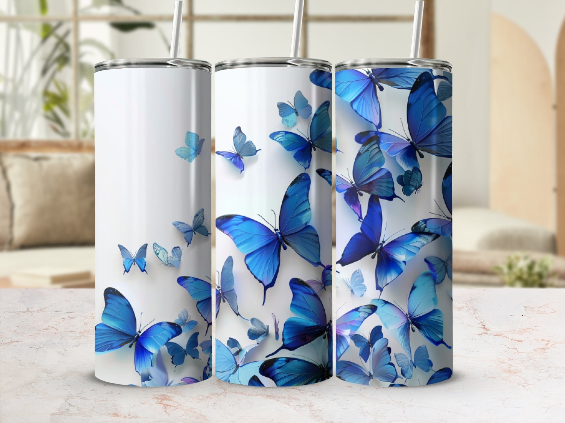 Three white tumblers adorned with blue butterflies in various sizes and orientations.