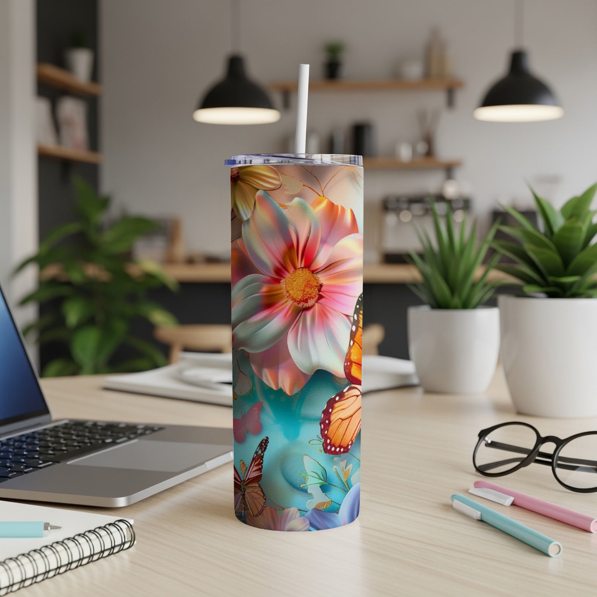 Tumbler with vibrant floral and butterfly design on a desk.