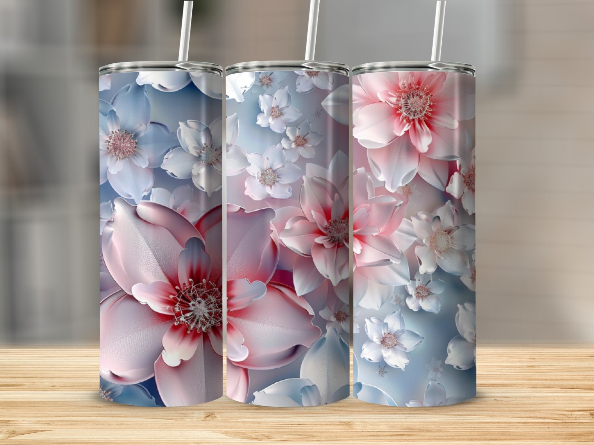 Three floral tumblers with pink and white blossoms on a light blue background.