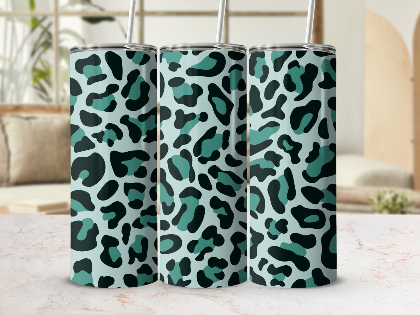 Three tumblers with teal and black leopard print and silver straws.