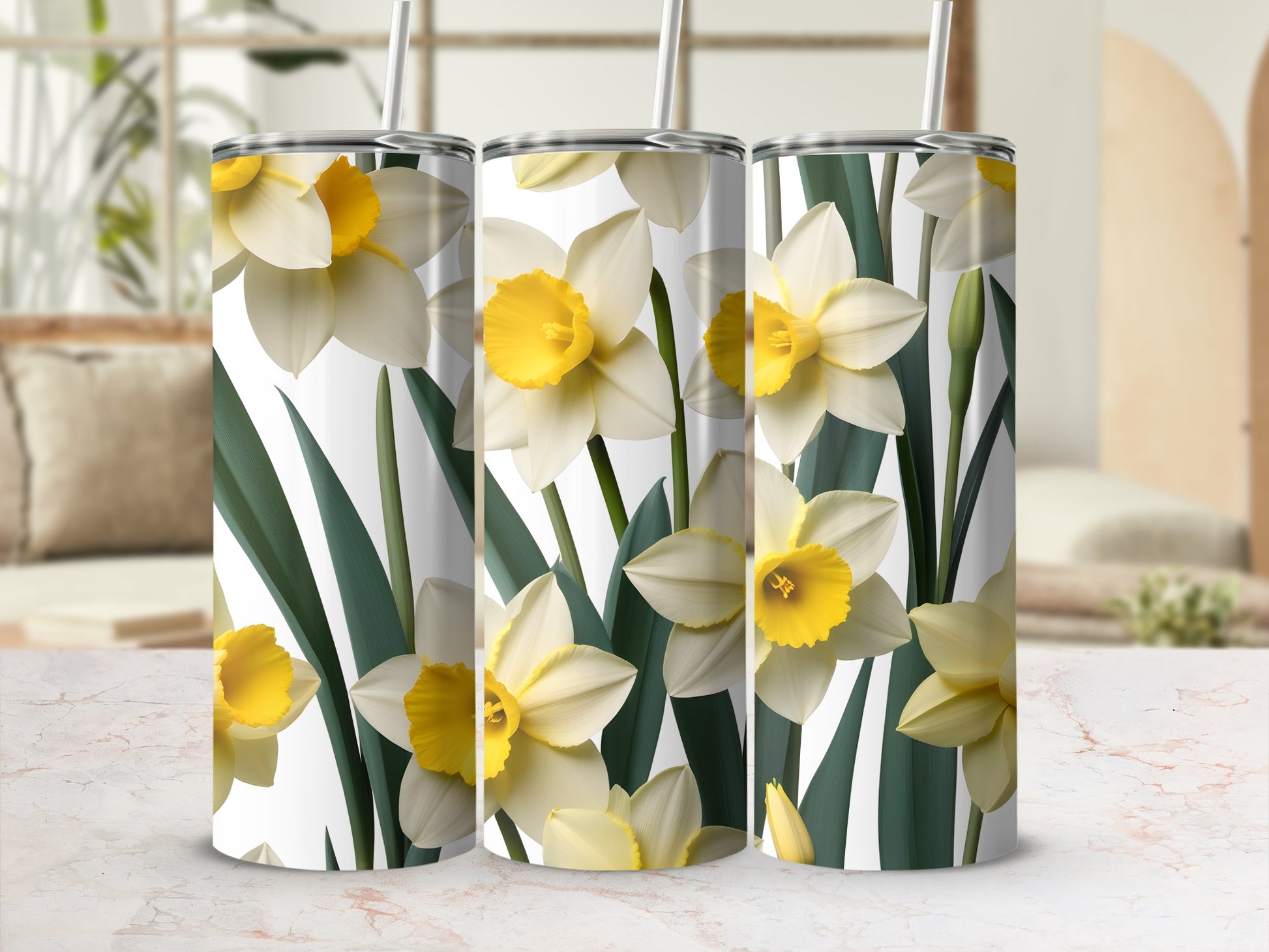 Three tumblers with a repeating pattern of yellow and white daffodils and green leaves.