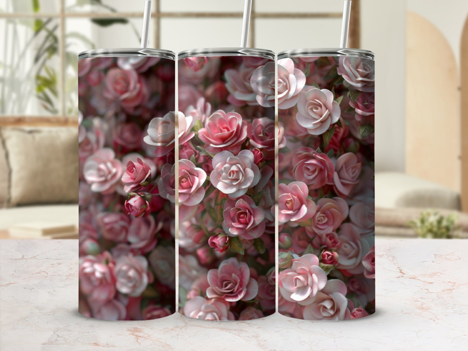 Three tumblers with a pink floral pattern displayed on a marble countertop.