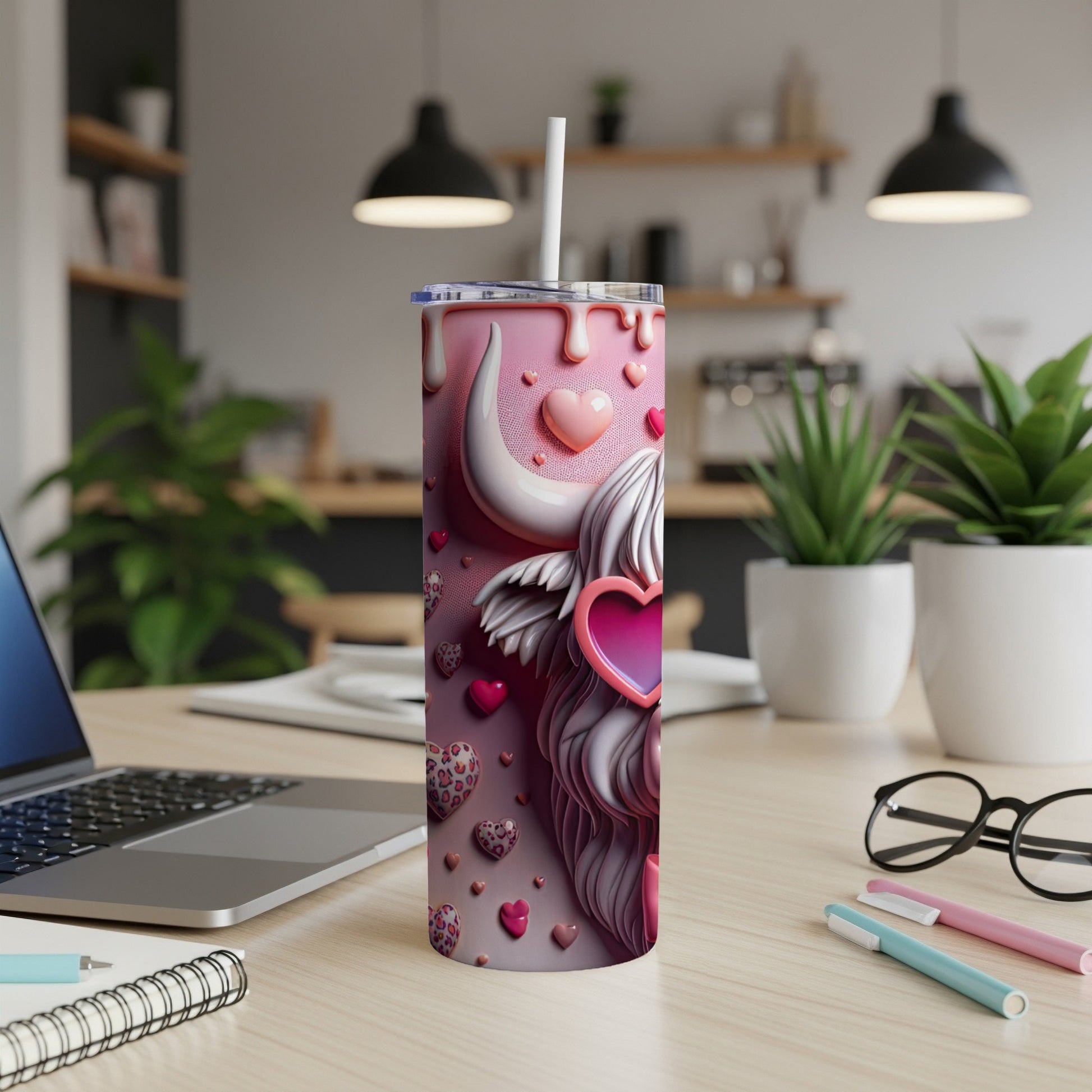 Pink tumbler with Highland cow and hearts, on a desk.
