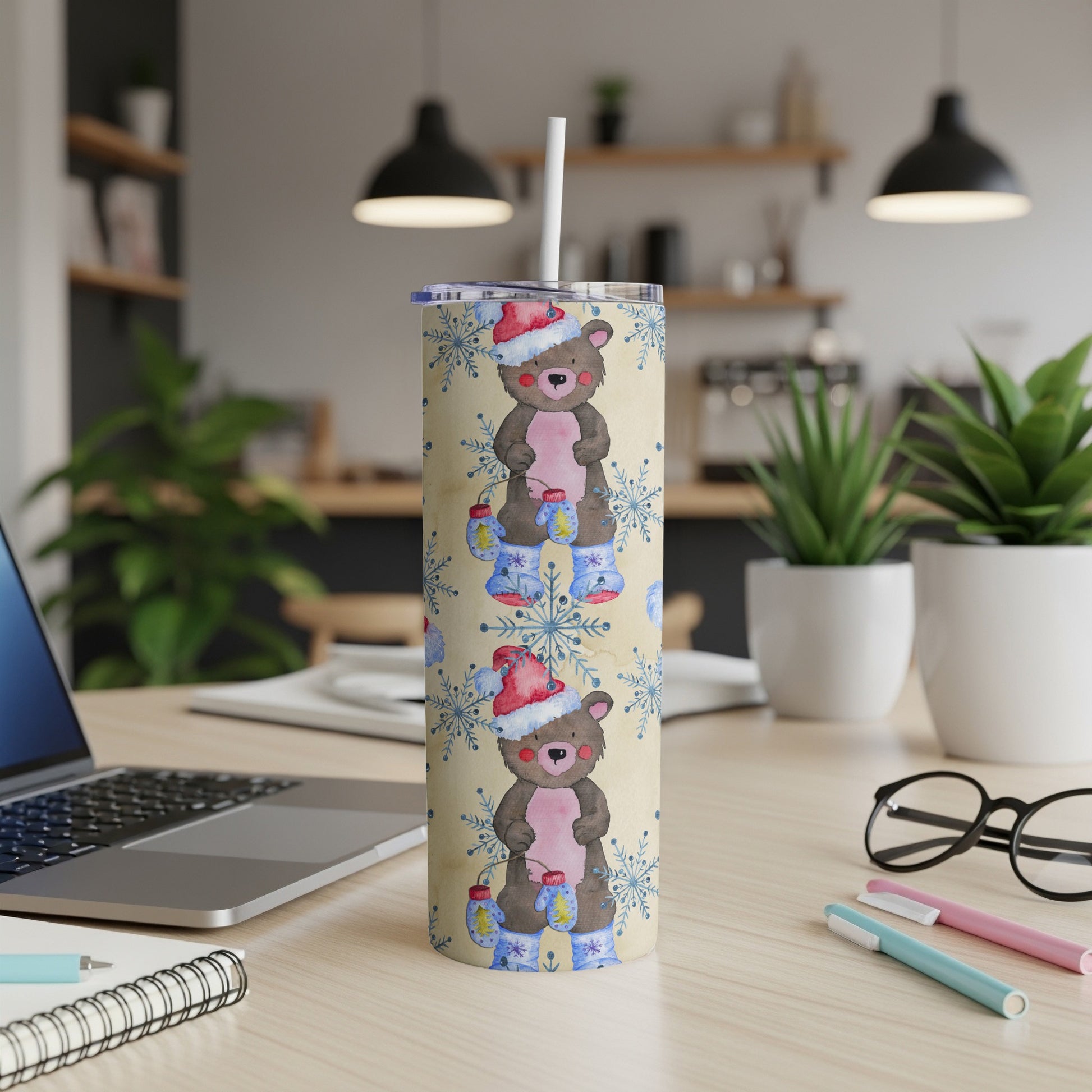 Bear and lantern pattern on a tan tumbler with snowflakes and a blue lid.