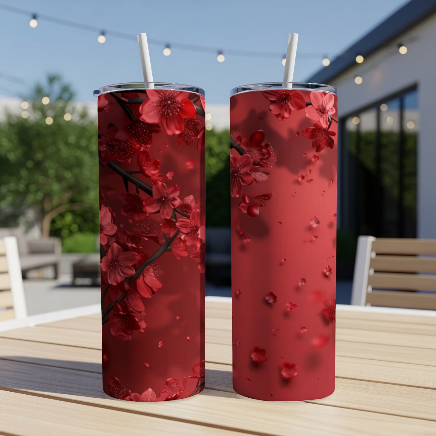 Two red tumblers with a floral cherry blossom design on a wooden table.