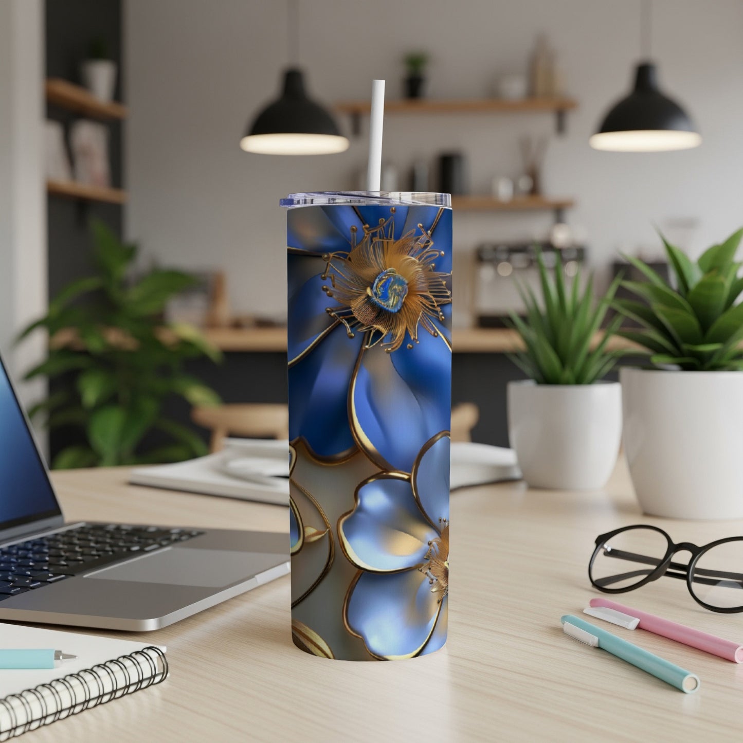Blue floral tumbler with gold accents on a desk.