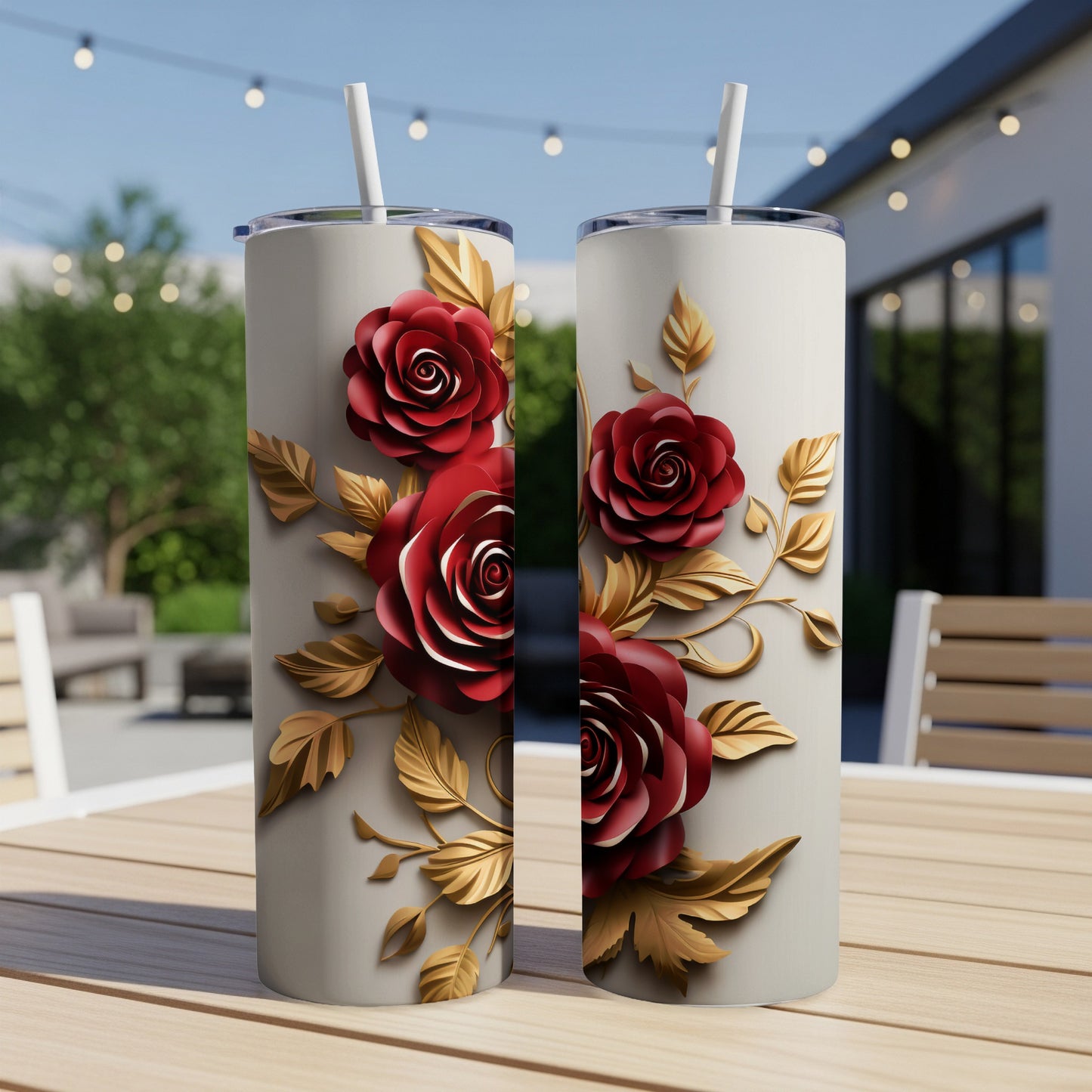 Two tall, narrow tumblers with red roses and gold leaves on a wooden table.
