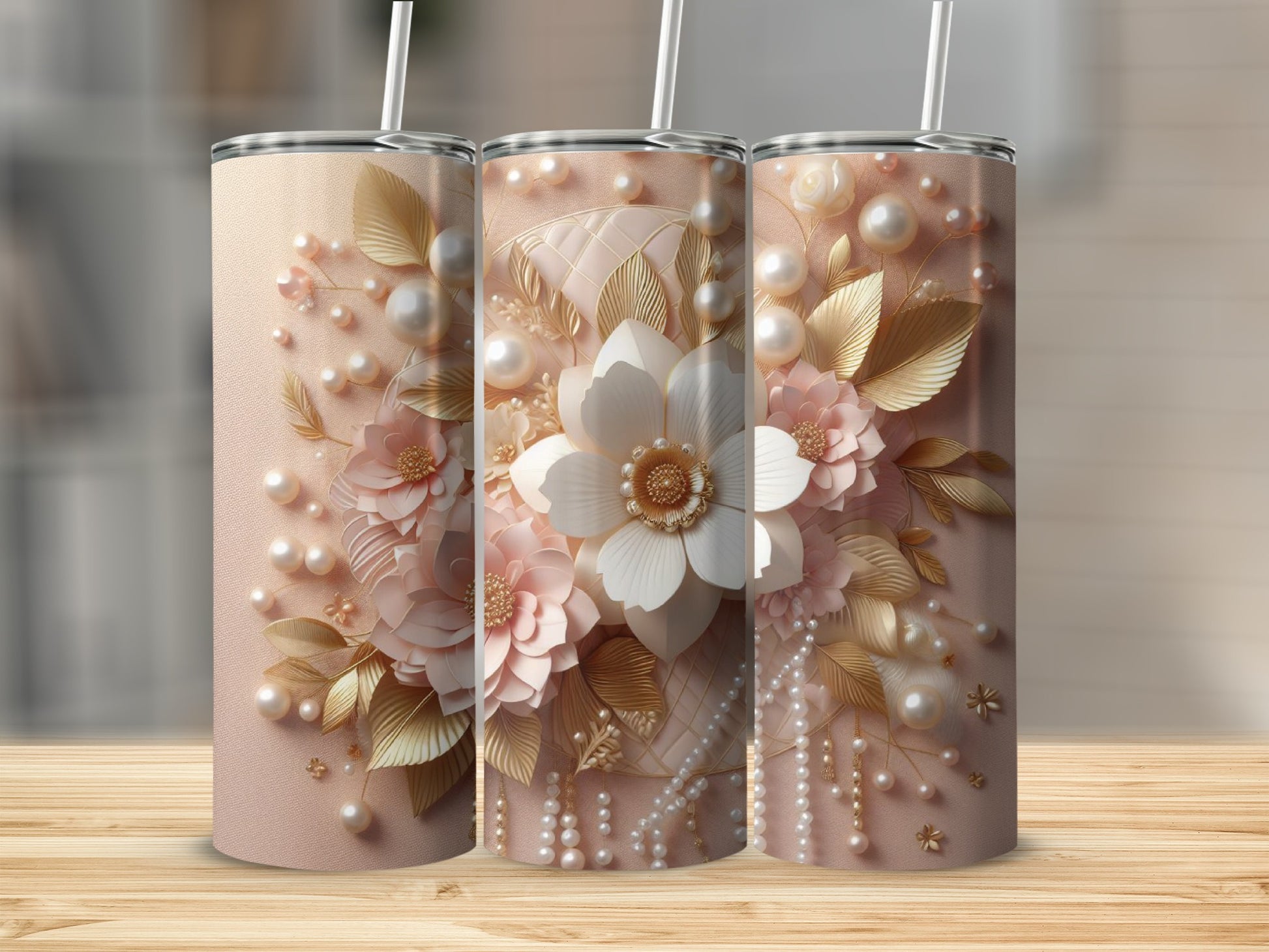 Three blush pink tumblers with floral and pearl embellishments.