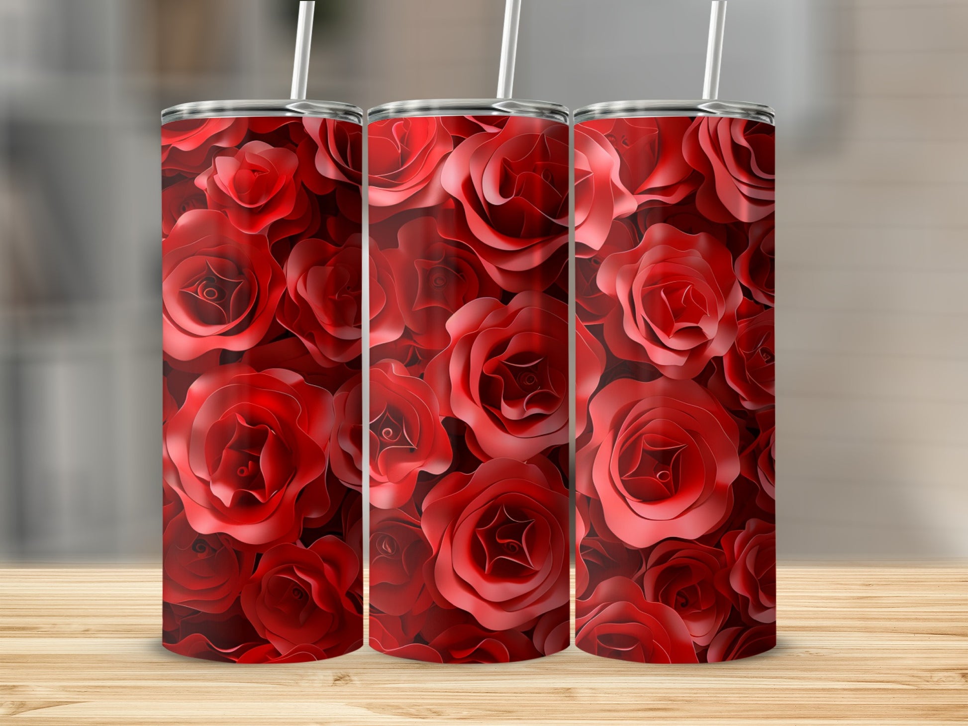 Three tumblers with a red rose floral pattern on a wooden surface.
