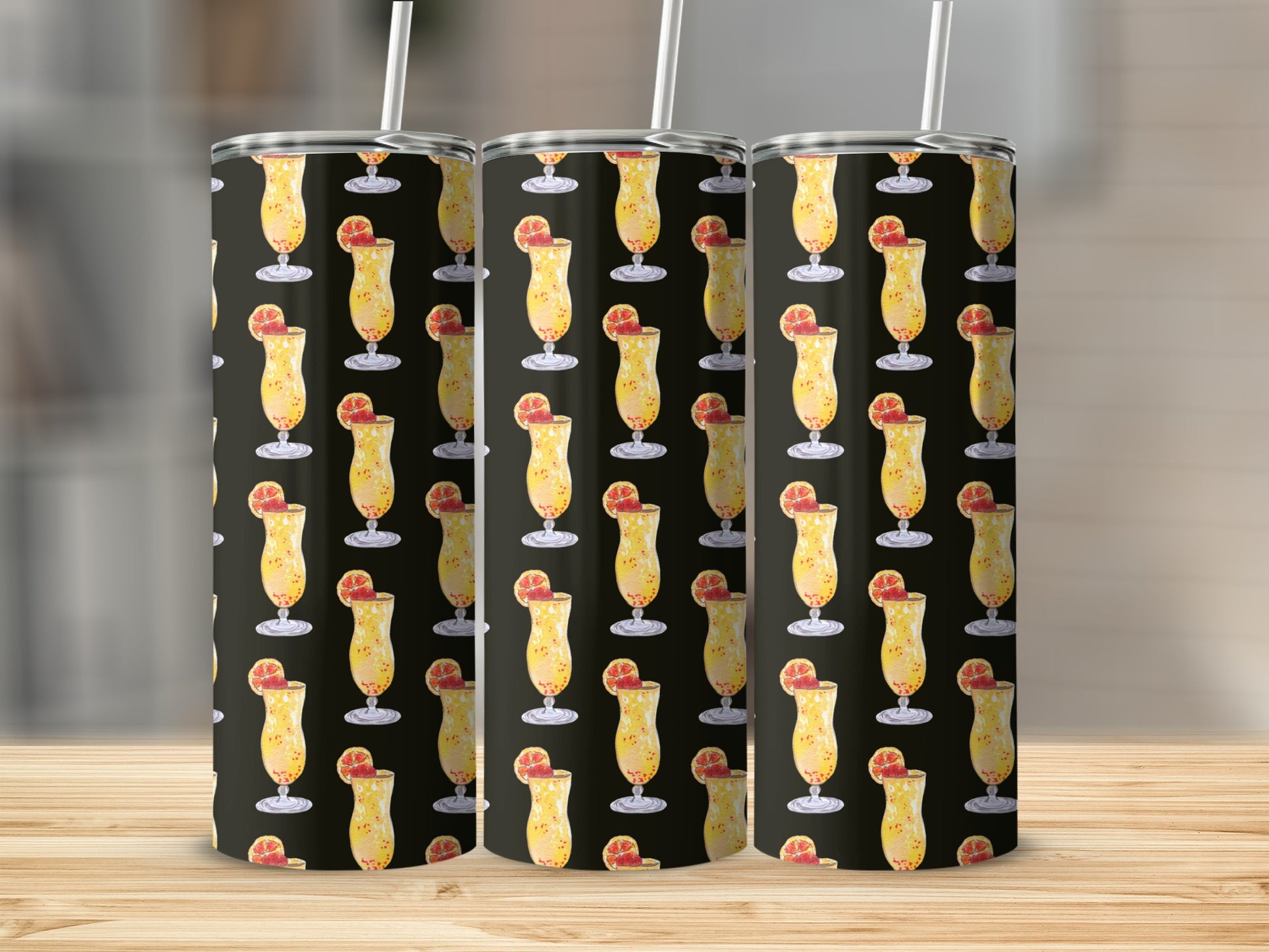 Three tumblers with a tropical drink pattern on a wooden surface.