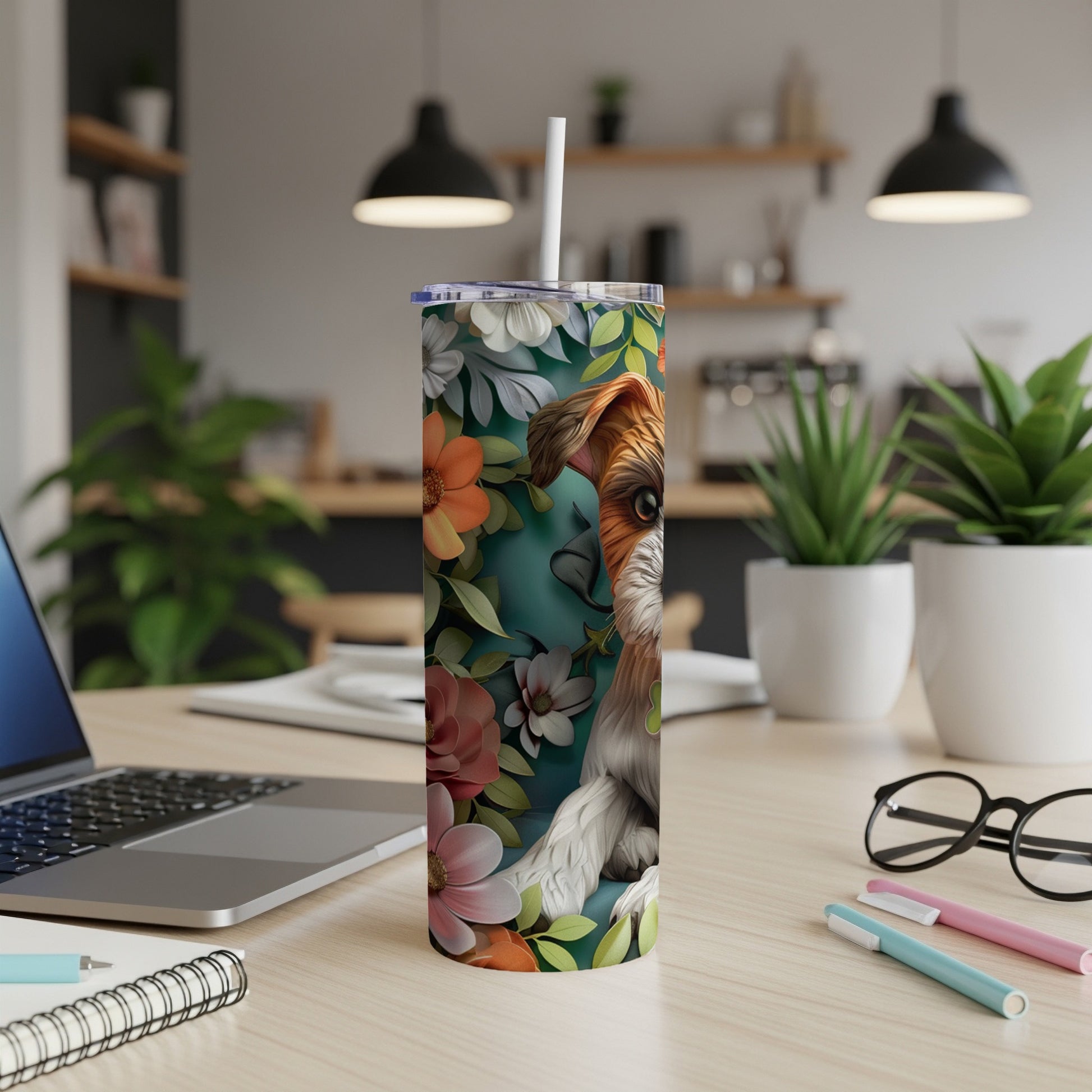 Floral patterned tumbler with dog illustration on a desk.
