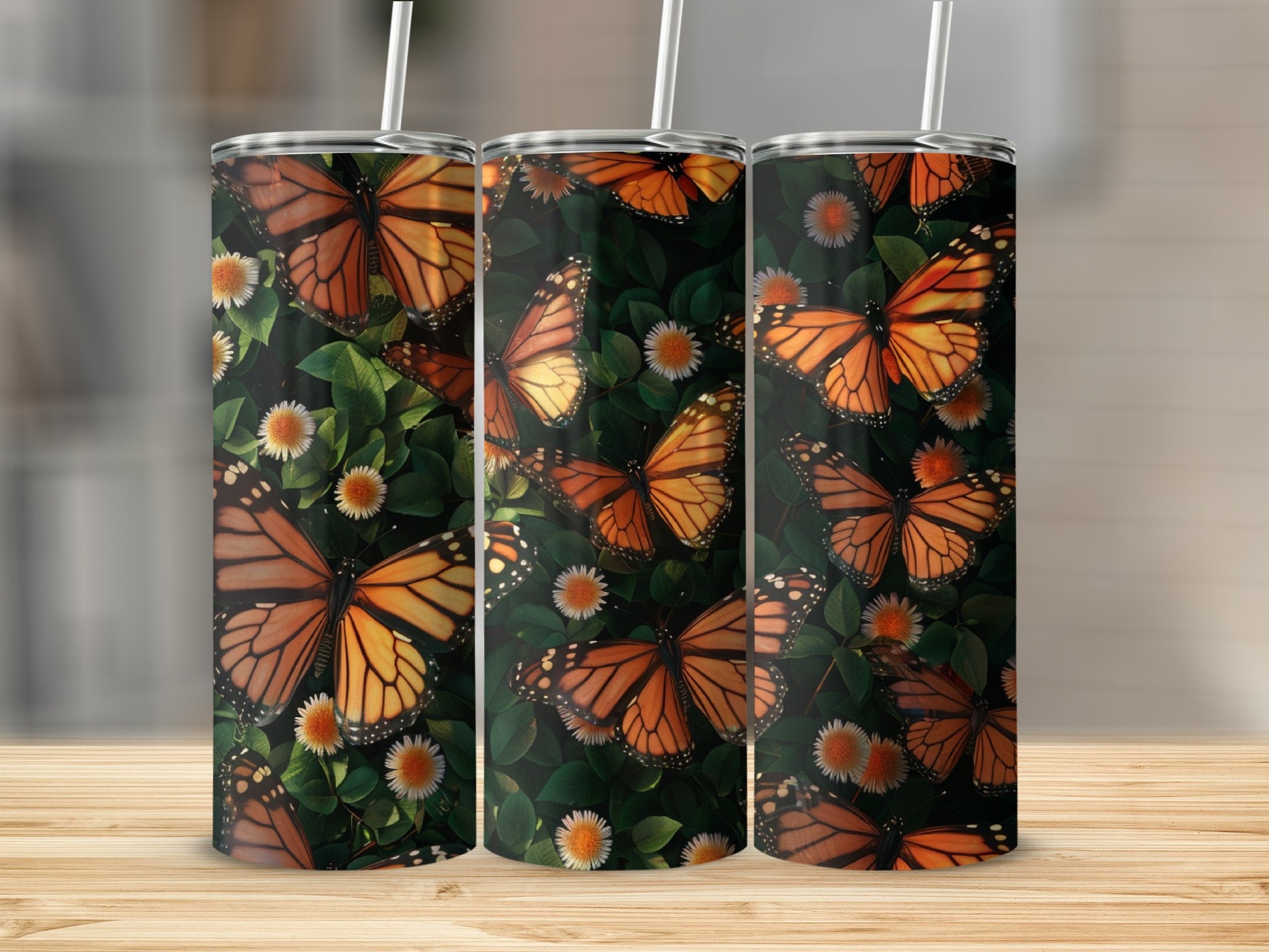 Triptych of tumblers with monarch butterflies and white flowers on dark green foliage.