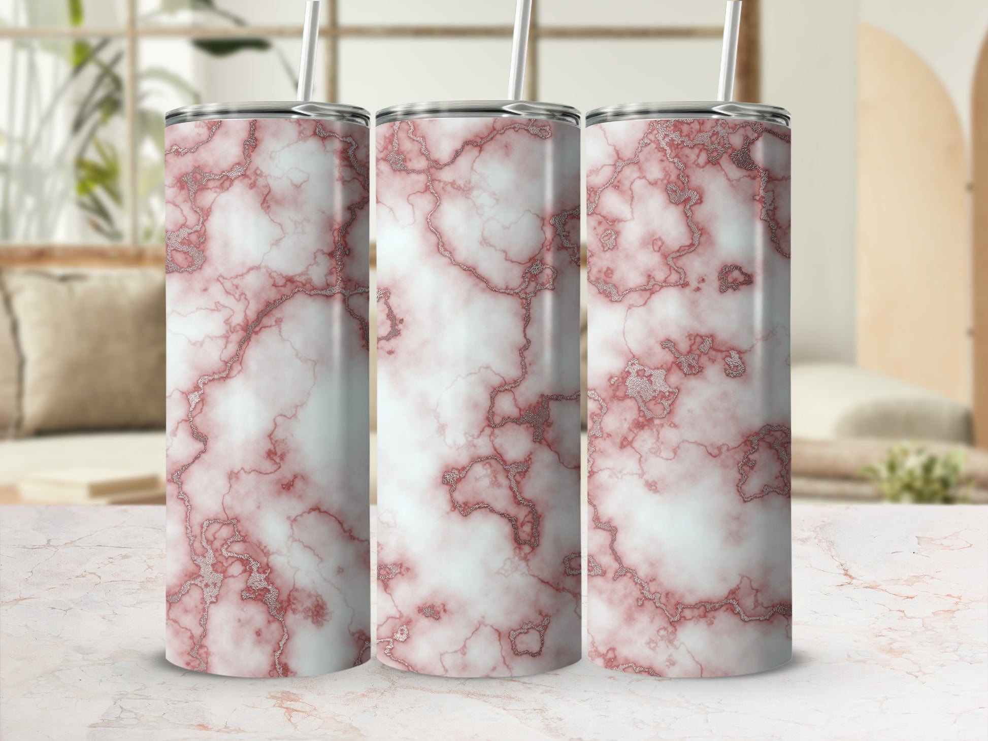 Three tumblers with pink and silver marble pattern on a marble surface.