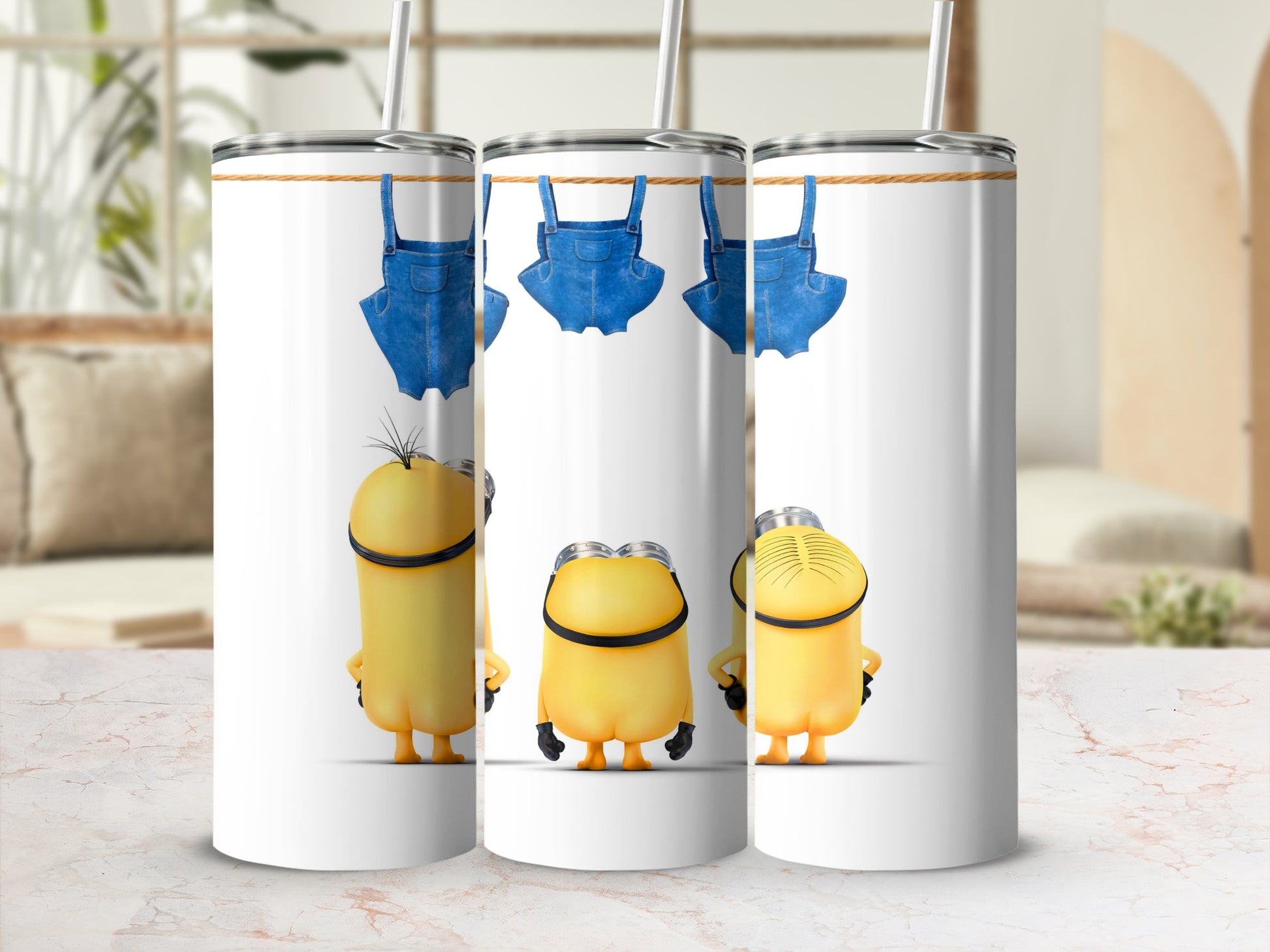 Three Minions with denim overalls hanging from a clothesline on a white tumbler.
