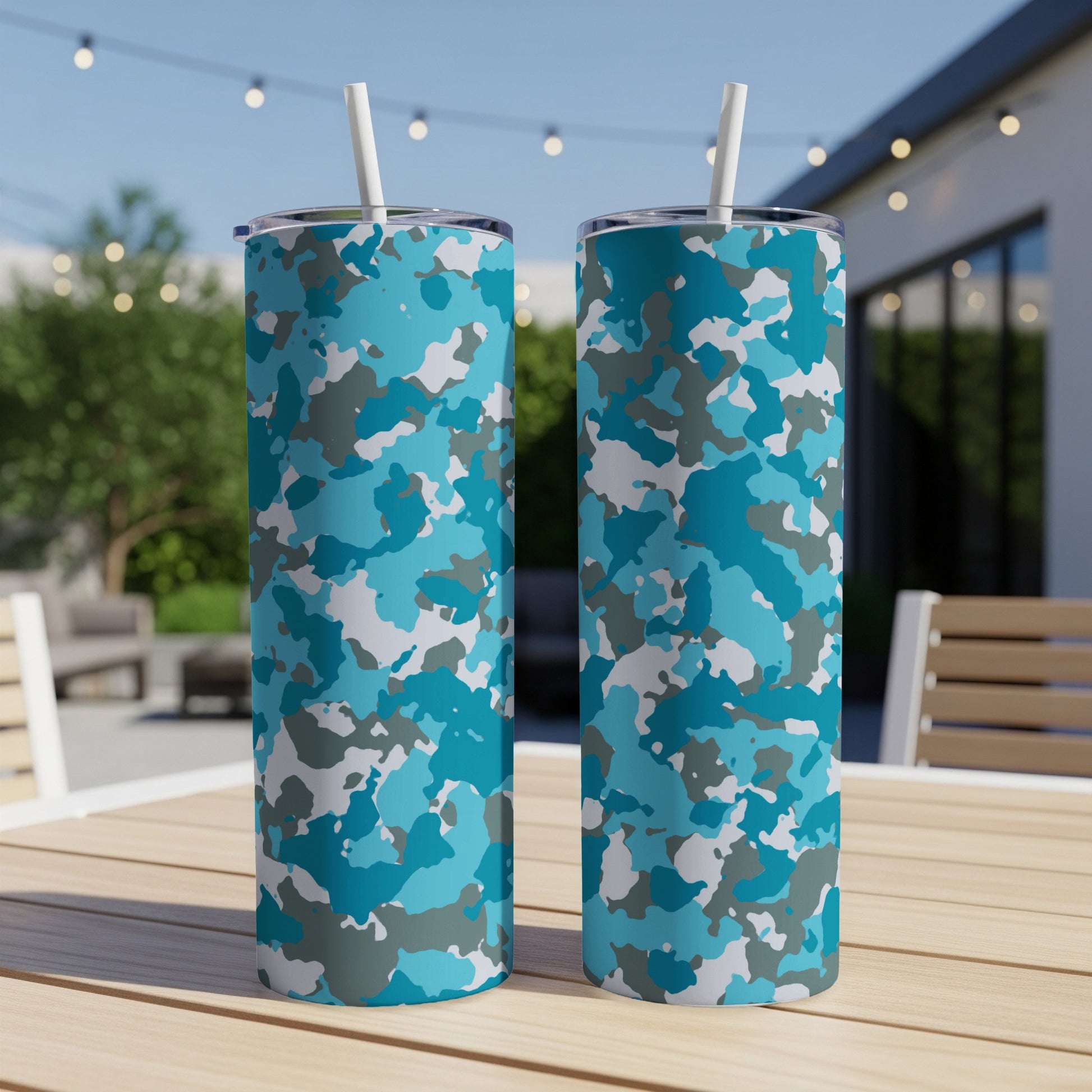 Two tall tumblers with blue, grey, and white camouflage pattern and straws.