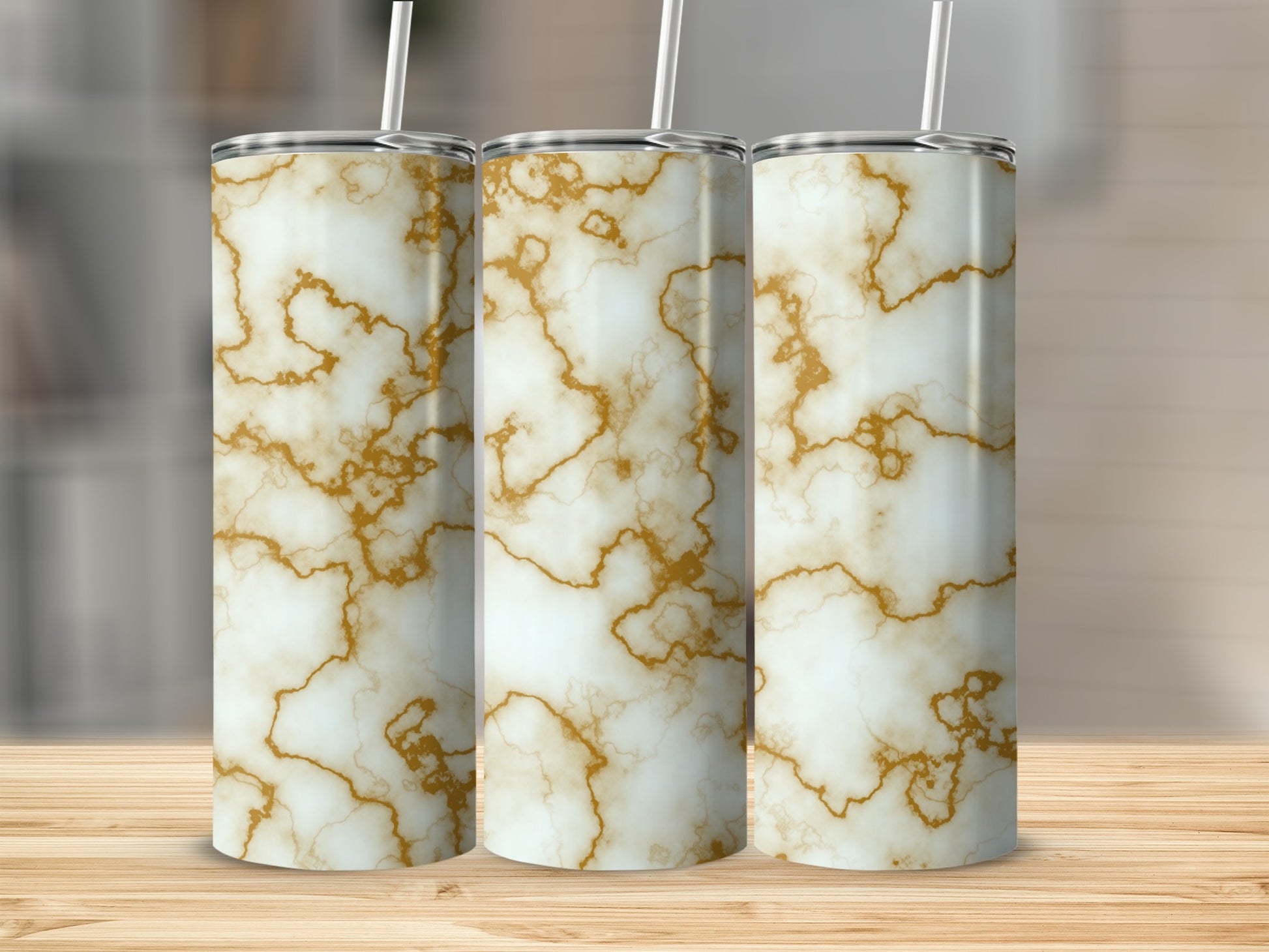 Three tall tumblers with a white and gold marble pattern and straws.