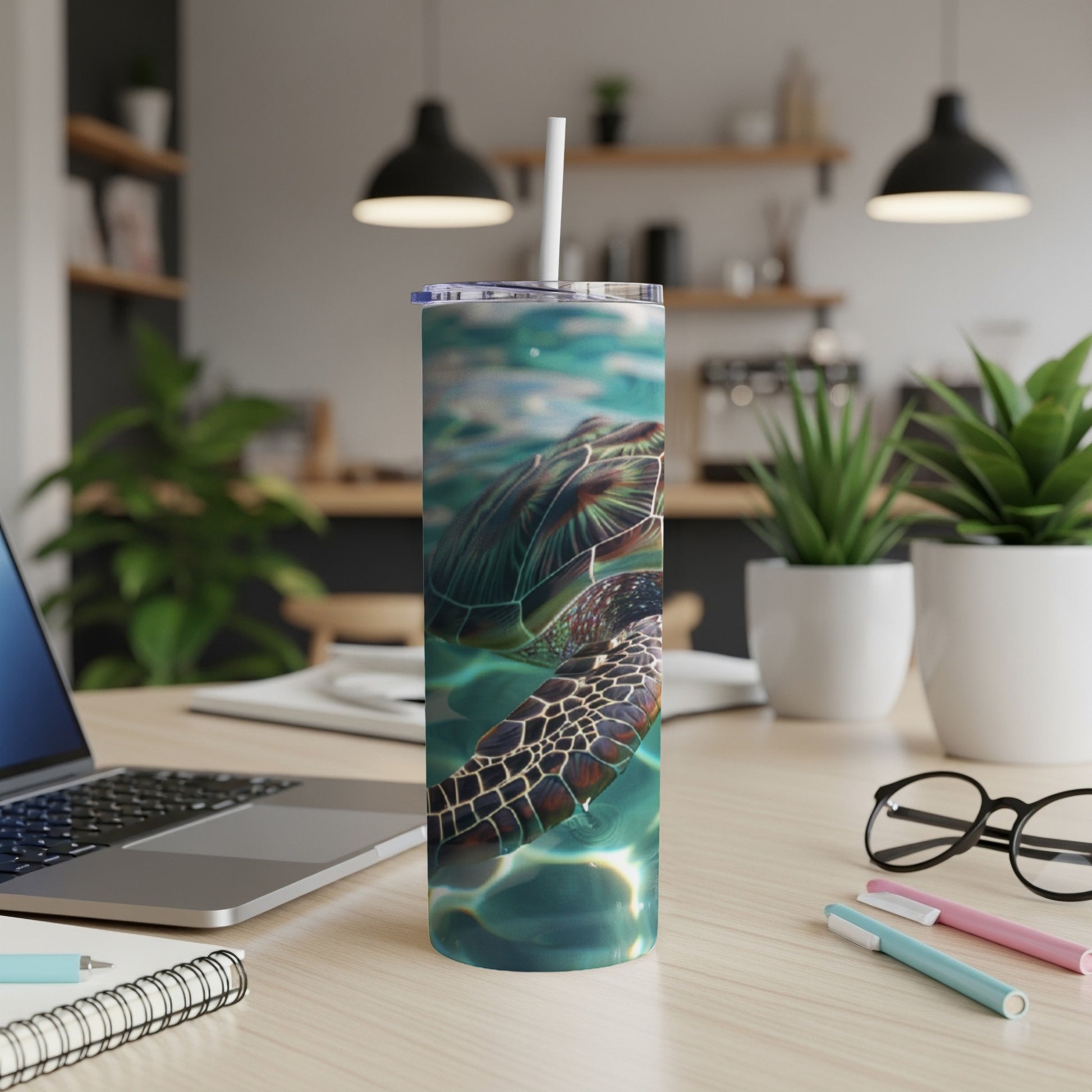 Sea turtle swimming underwater on a stainless steel tumbler with straw.