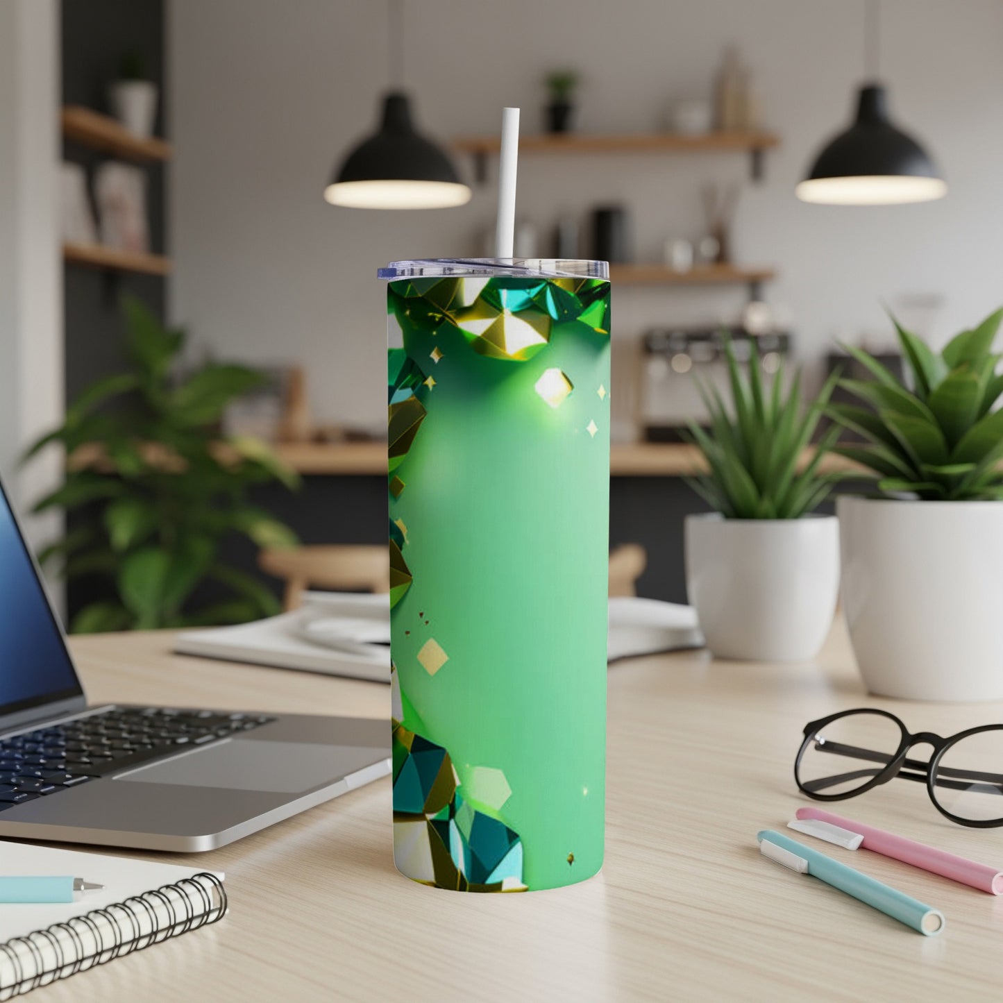 Green glitter tumbler with geometric accents and a white straw on a desk.