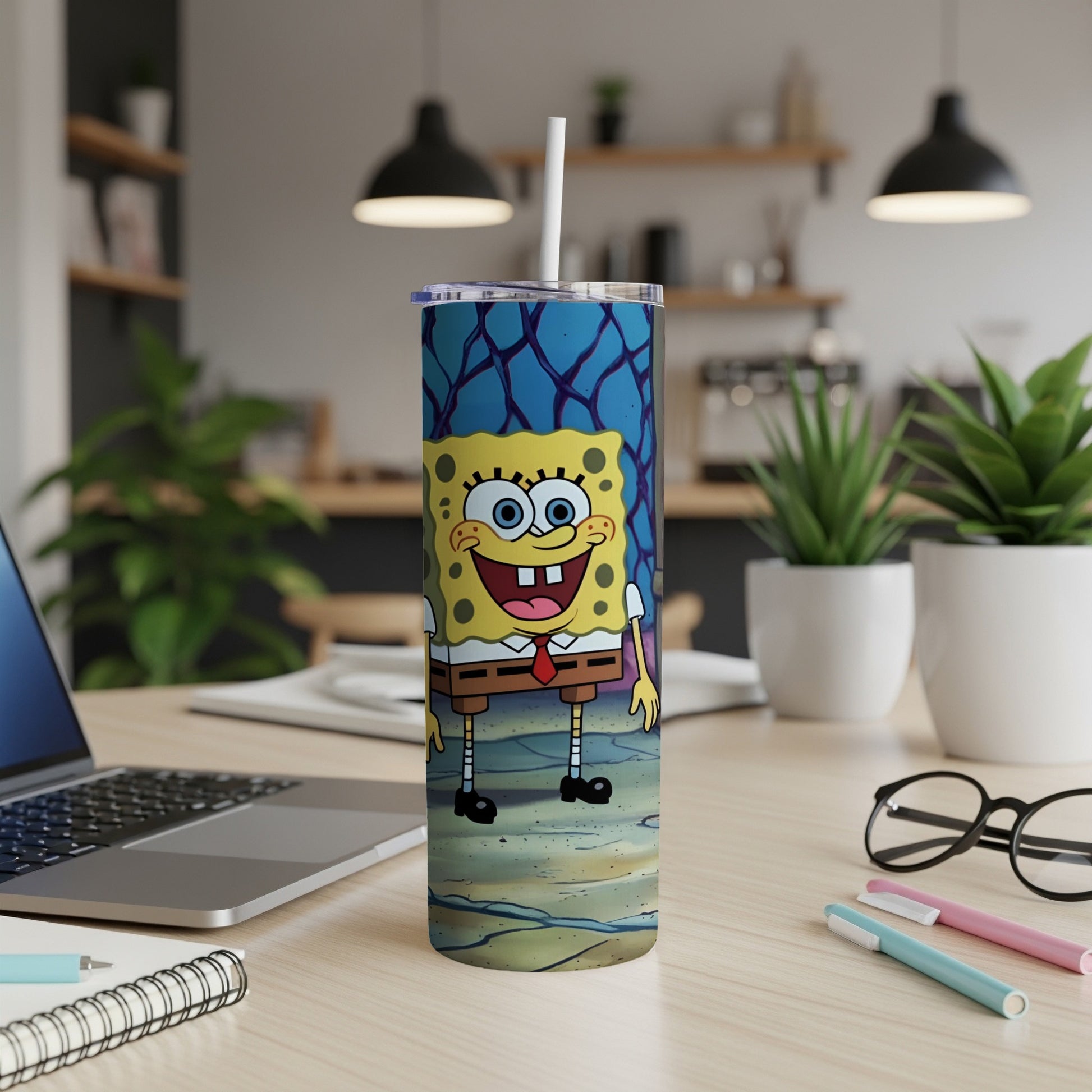 SpongeBob SquarePants tumbler with lid and straw on a desk.