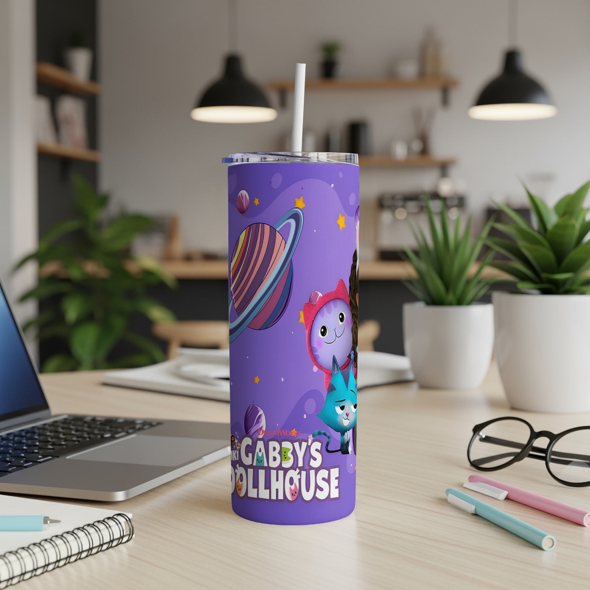 Gabby's Dollhouse tumbler with characters and planets, on a desk.