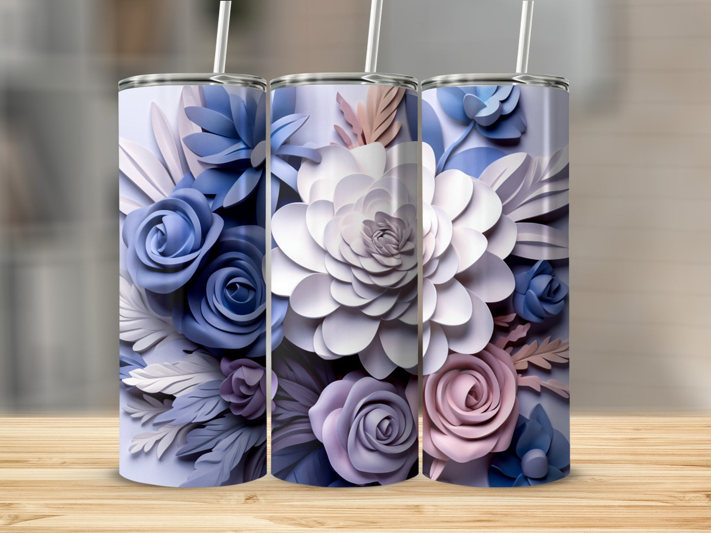 Three tumblers with floral designs in shades of blue, purple, and pink.
