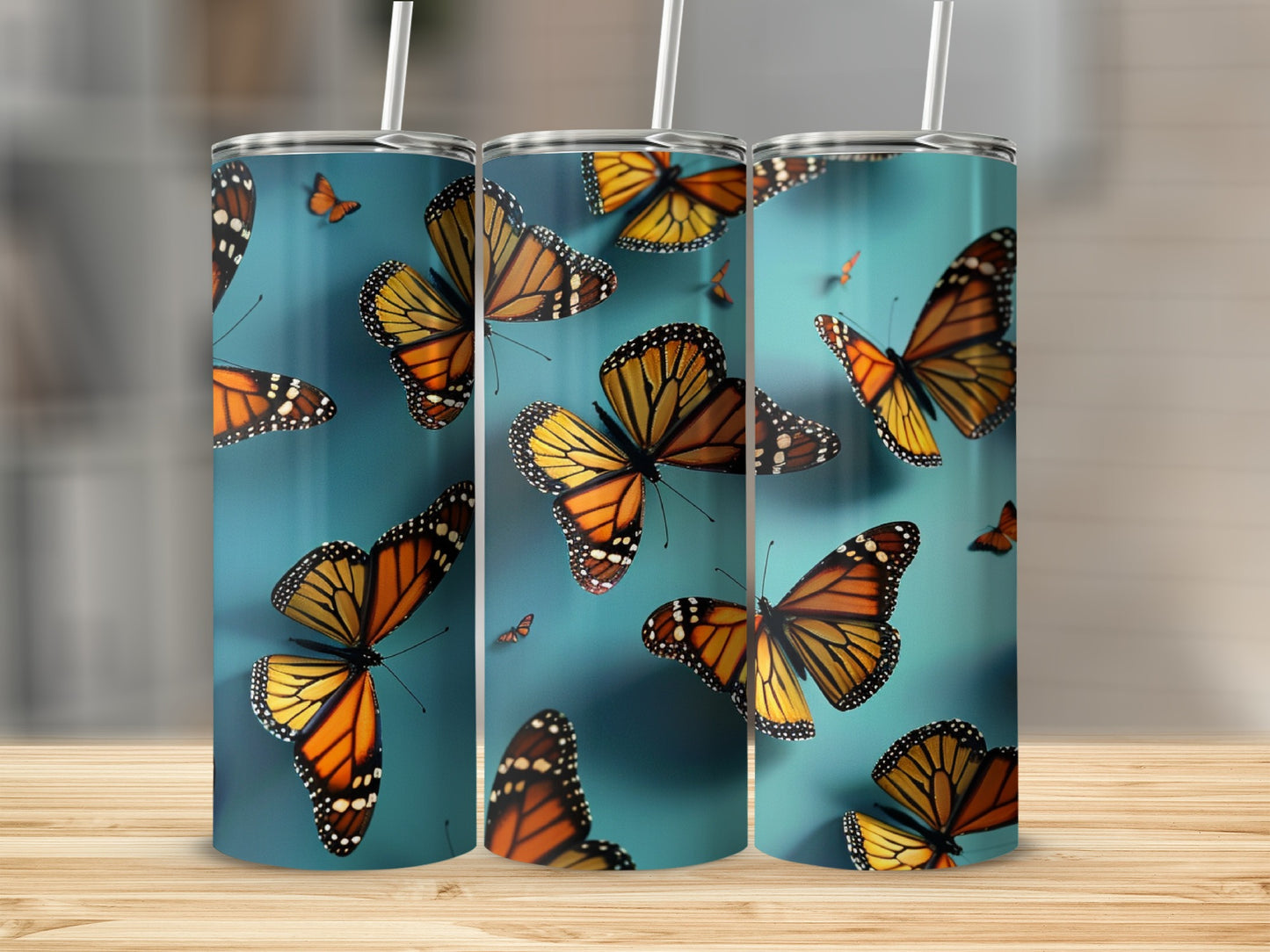 Monarch butterflies on a teal background, presented on three tumblers.