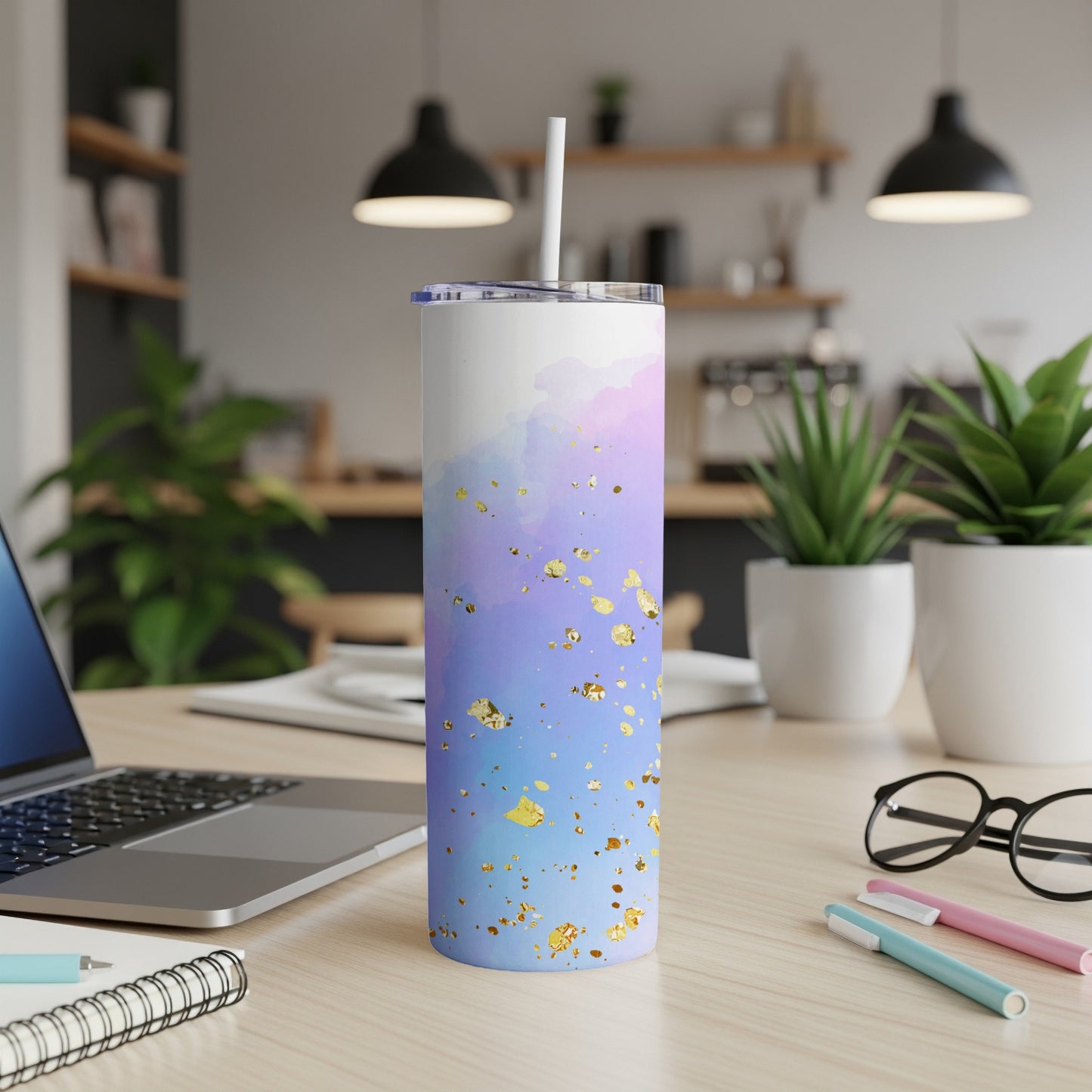 White tumbler with blue, purple, and gold watercolor design and straw.